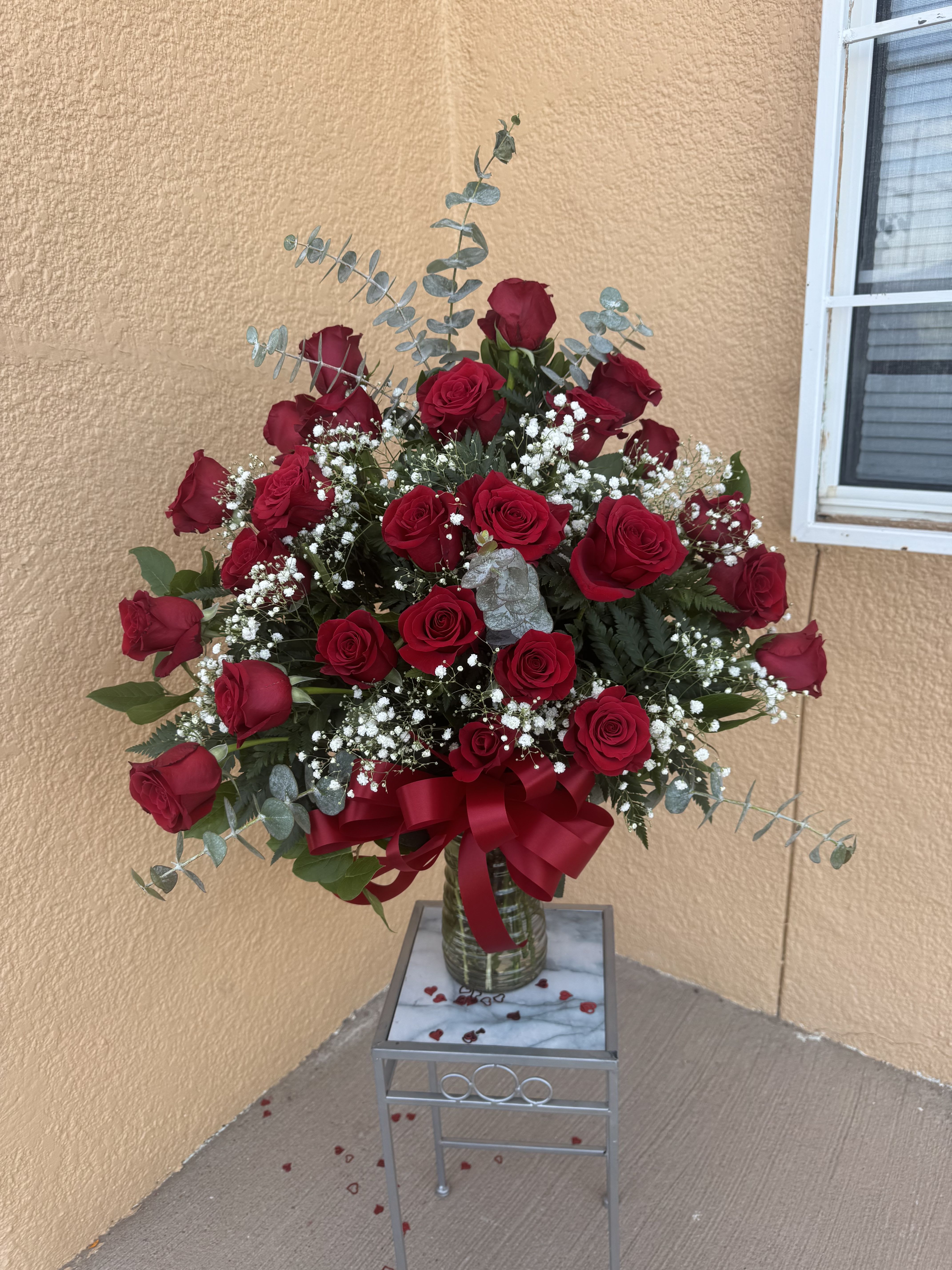Two Dozen Red Rose Arrangement  - Elegant and timeless, this beautiful arrangement features fresh premium red roses accented with delicate baby’s breath and lush greenery, finished with a romantic satin bow in a clear glass vase. Perfect for anniversaries, romantic occasions, or sending a heartfelt surprise. Same-day delivery available in El Paso.
