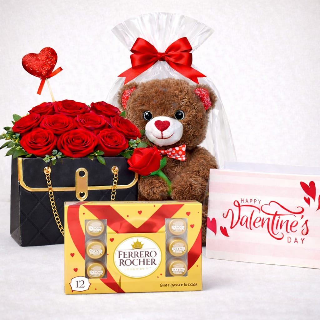 Luxury Love Deluxe Gift Set - An unforgettable deluxe Valentine’s gift featuring a sophisticated handbag-style rose arrangement filled with lush red roses, a plush teddy bear wrapped with a satin bow, a Ferrero Rocher chocolate collection, and a romantic Valentine’s greeting card. A complete luxury surprise designed to impress and celebrate love in the most beautiful way.  Better for: Valentine’s Day, anniversaries, engagements, romantic occasions, I love you. 