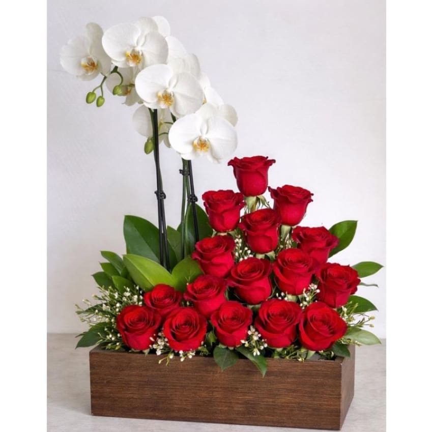 Orchid &amp; Red Rose Garden - A refined floral composition featuring a lush arrangement of premium red roses beautifully paired with elegant white phalaenopsis orchids. Designed in a natural wooden planter and accented with fresh greenery and delicate filler flowers, this sophisticated arrangement blends romance and modern elegance, creating a striking statement for any special moment.  Better For: Anniversary, Romantic Gift, Birthday, Congratulations, Luxury Floral Gift, Home Décor, Thank You