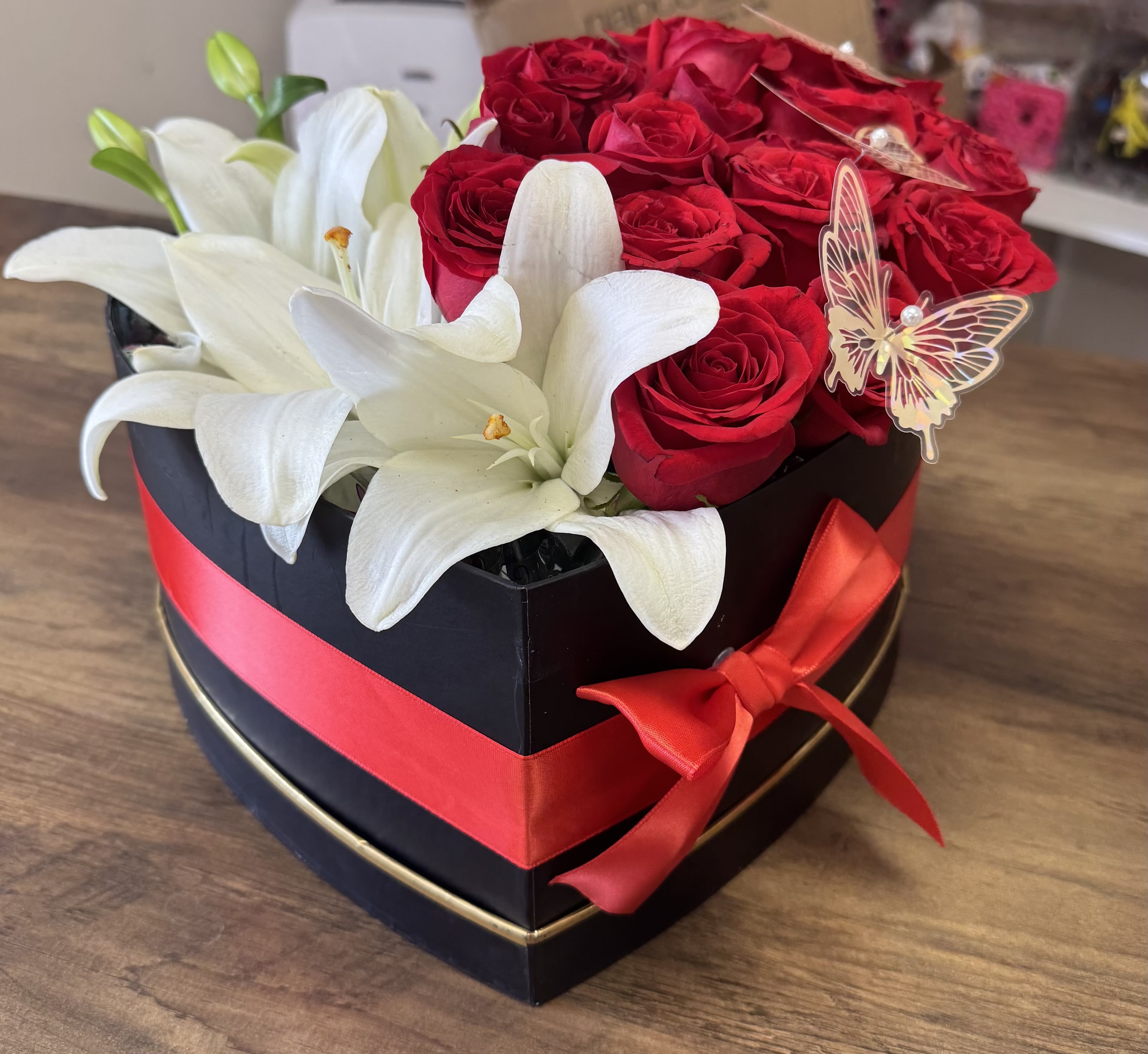 All from the Heart - Make a bold romantic statement with this elegant heart-shaped arrangement featuring premium red roses and fresh white lilies, beautifully designed in a luxury keepsake box with a satin ribbon. Perfect for anniversaries, romantic surprises, Valentine’s Day, or special occasions. Handcrafted by Amour Flowers with same-day flower delivery available in El Paso, Texas.