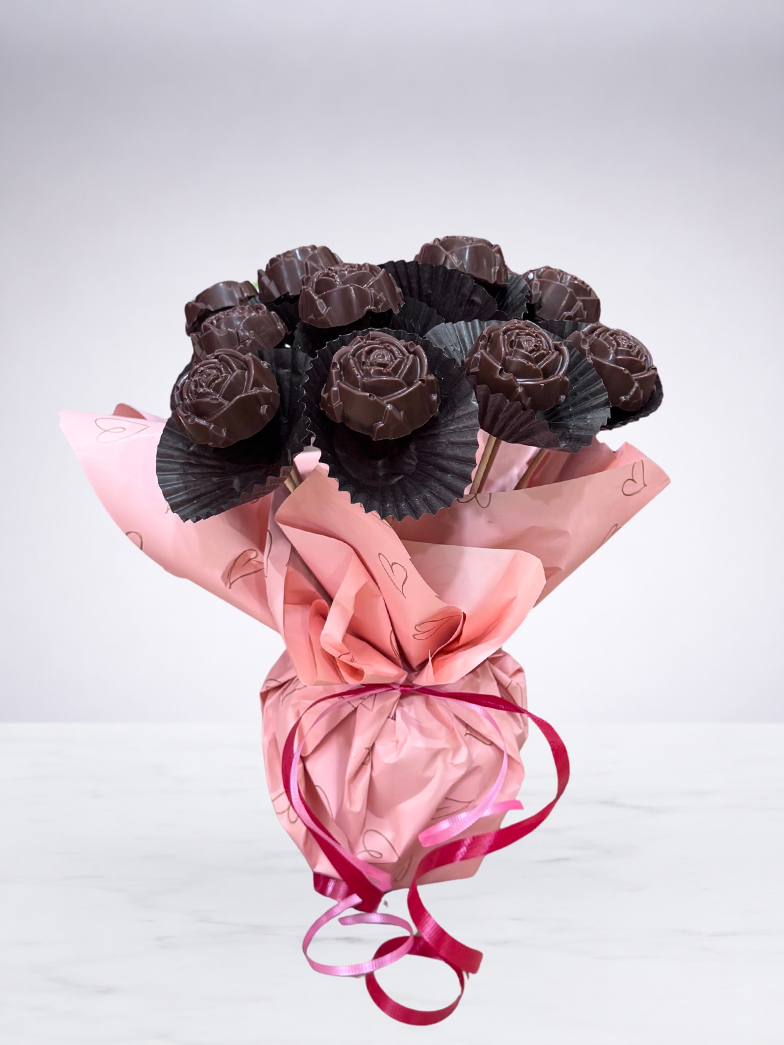 Chocolate Rose Bouquet - A sweet twist on a classic bouquet. This arrangement features strawberry chocolate-covered roses crafted to look like real flowers, displayed on sticks and wrapped like a traditional bouquet. Rich, decadent chocolate meets timeless romance—perfect for Valentine’s Day, anniversaries, or anytime you want to surprise someone with something a little unexpected. Beautiful to display and even better to enjoy.