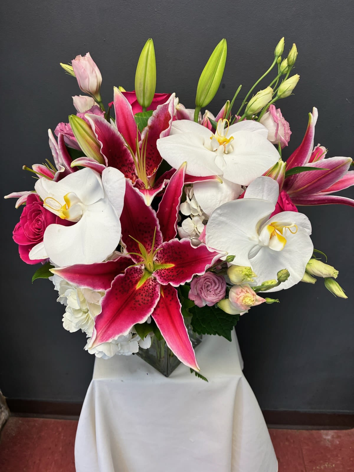 Cara Bonita  - Flirty stargazer lilies wink among dreamy blush roses and lisianthus and graceful orchids, and hydrangeas creating a bouquet that feels like a love letter in petals. With soft curves, sweet scents, and a touch of whimsy, it’s perfect for moments that deserve a little extra heart—whether it’s a wedding, anniversary, or just because.