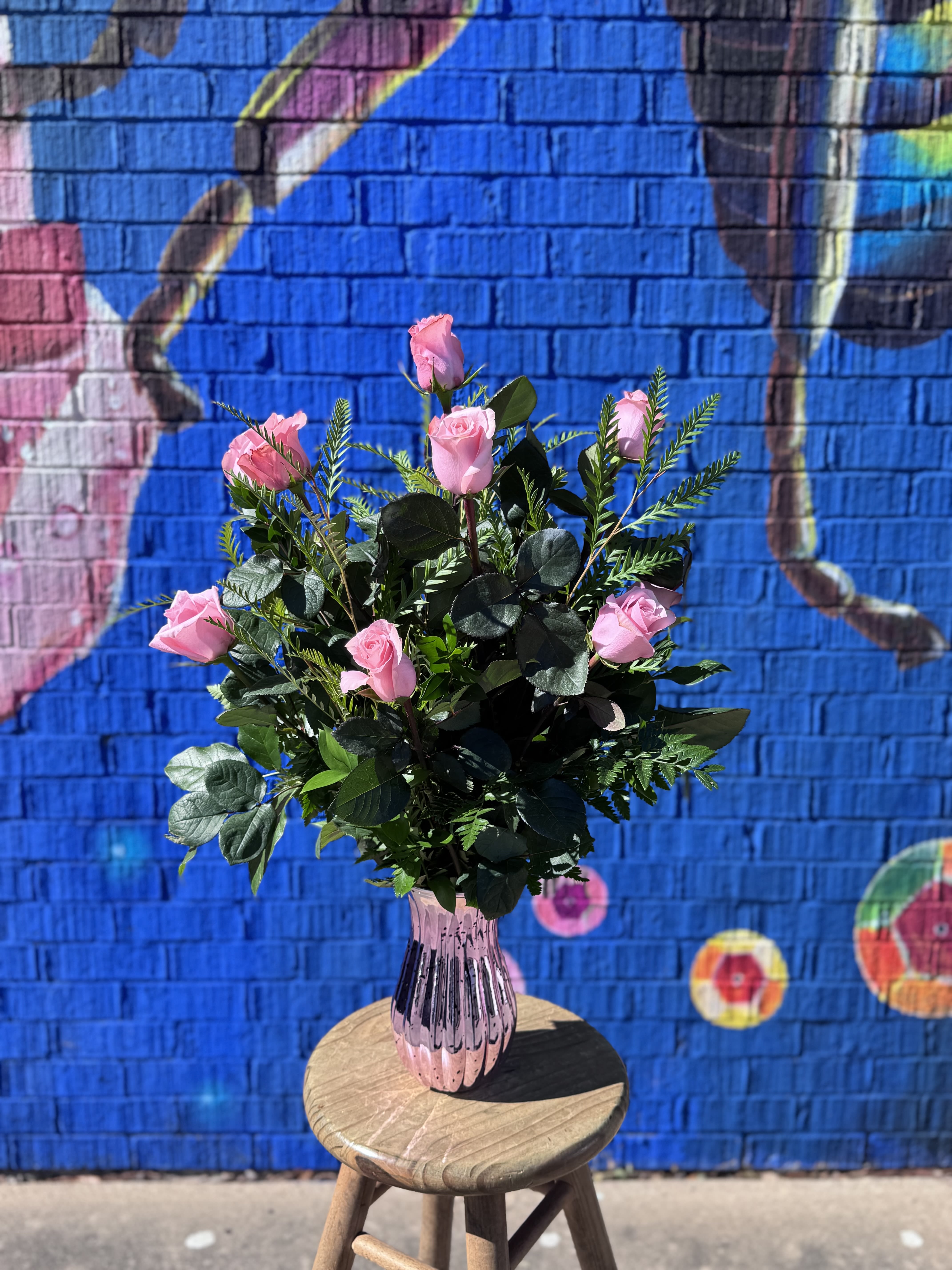 One Dozen Pink Rose - Twelve long-stemmed premium pink roses designed in a vase with complimenting lush greenery. Deluxe version adds complimenting accent flowers to the standard version. Premium adds 4 Oriental lilies to the deluxe version.