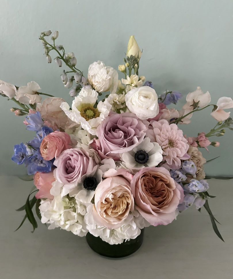 Tara Arrangement - Elegant arrangement of gorgeous dusty golden, sandy, coral colors. Arranged in a 5" by 6" clear cylinder vase. Roses, anemones, and seasonal flowers and light greens adorn this classic arrangement. Blomst LA only uses fresh, high quality flowers, all carefully selected every day to fit your flower order. Measures appx 12" by 10". Chose the Deluxe for a larger arrangement, arranged in a 6" by 6" clear cylinder vase, measurements appx 13" by 11" or the Premium size for a larger arrangement, arranged in a 6" by 6" clear cylinder vase, measurements appx 14" by 12". We offer a personal hand delivery by our own delivery staff and guarantee the flowers will look perfect, when they arrive. We deliver in Glendale, Pasadena, Eagle Rock, Hollywood, Burbank, Beverly Hills - and everywhere else in Greater Los Angeles.