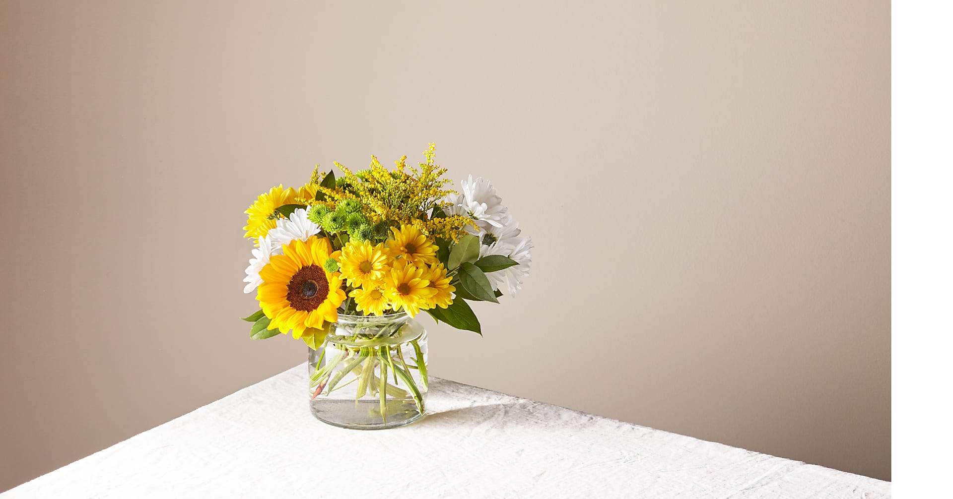 Hello Sunshine Bouquet by FTD - Give a dose of sunshine in bloom. This stunning bouquet is teeming with rays of sunflowers, textured snapdragons and darling daisy poms to deliver the perfect pick–me–up for an occasion or as a treat to yourself.