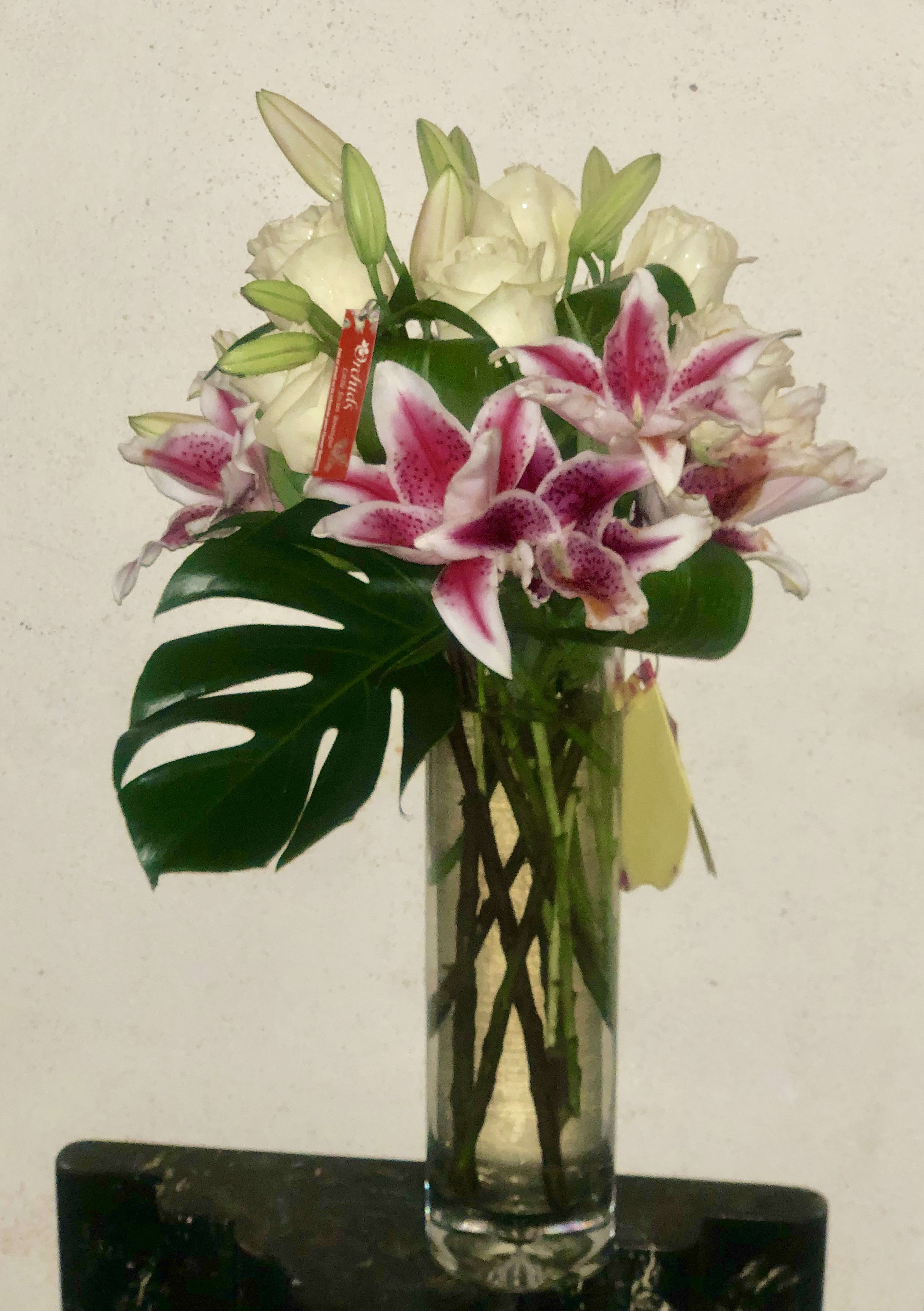 Elegant expression Stargazer Lily &amp; Long Stem White Roses - The elegant Style Bouquet is ready to express your thoughts to a special recipient with it's mix of bold and beautiful blooms! rich Stargazer Lilies and premium long stem white roses! Artistically arranged in a classic clear glass vase H"10