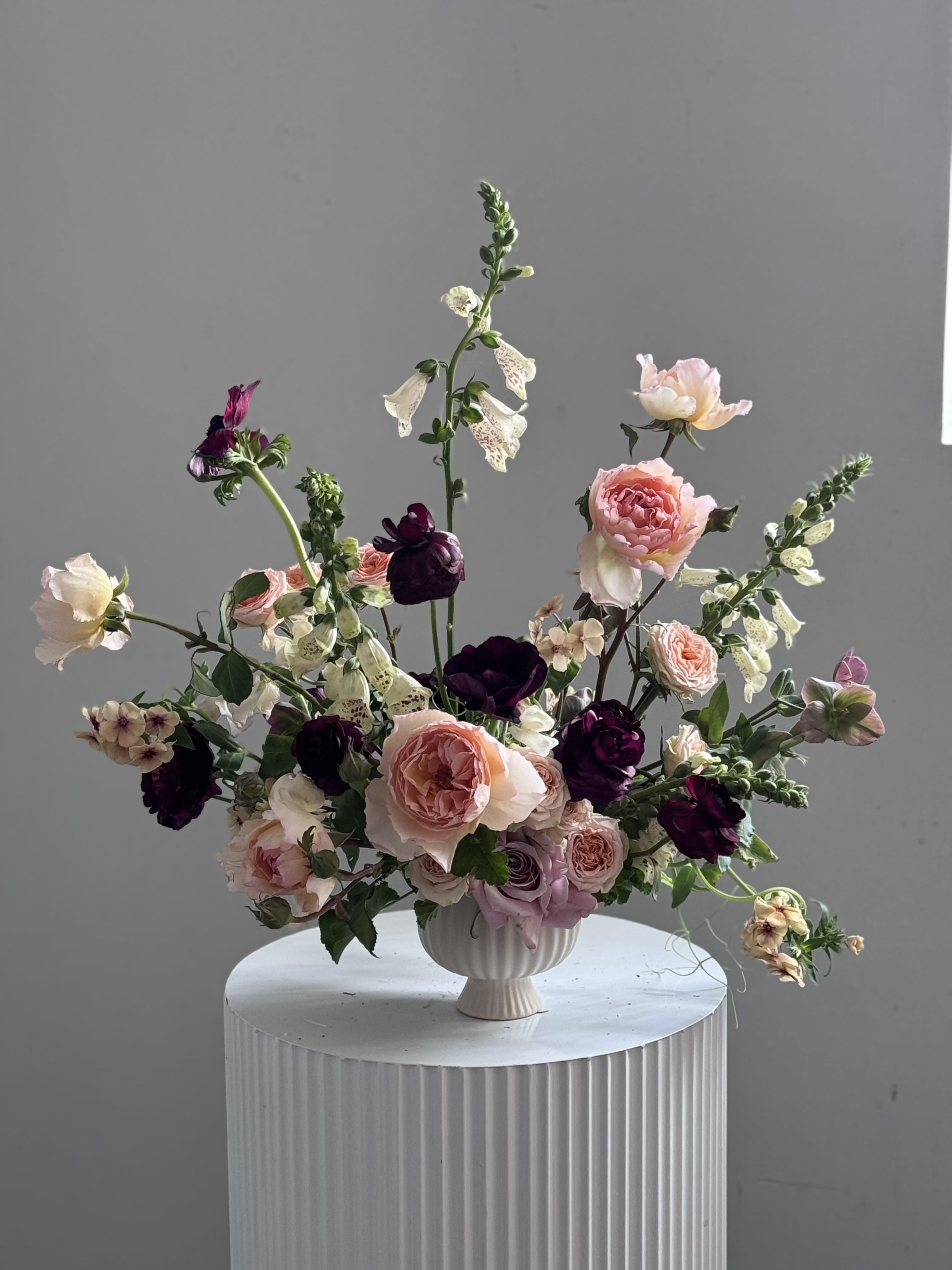 Midnight Petals - Midnight Petals -  a luxurious blend of depth and elegance, where the richness of burgundy meets the soft romance of blush. Dark, velvety roses in deep burgundy form the heart of this arrangement, exuding mystery and sophistication, while soft blush roses add a delicate, ethereal balance. Together, these blooms create a striking contrast that feels both passionate and serene.