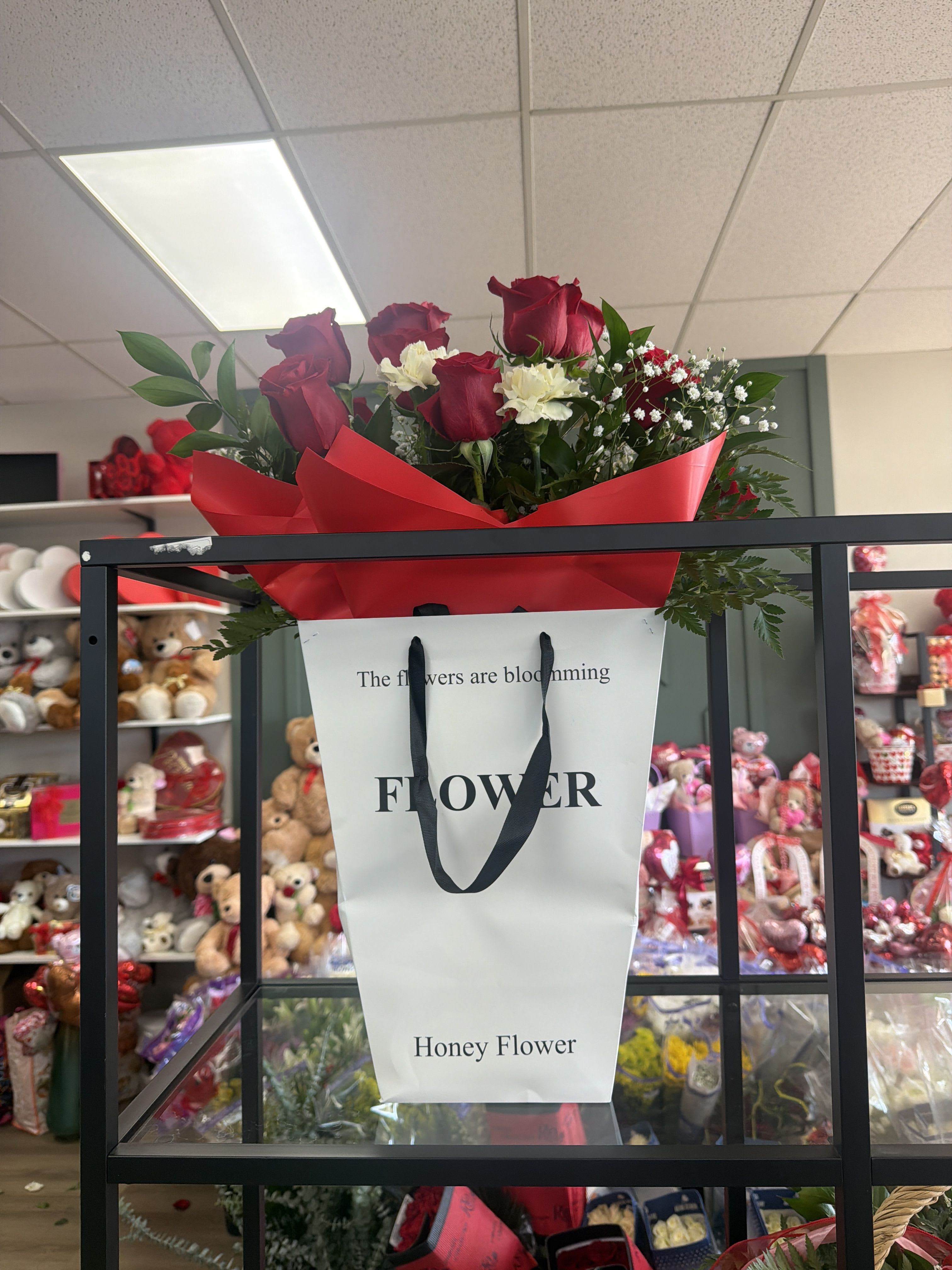 wrapped in Love - A classic bouquet of rich red roses accented with soft white blooms and fresh greenery, beautifully wrapped in premium paper. Elegant and timeless—perfect for love, anniversaries, or any romantic occasion.