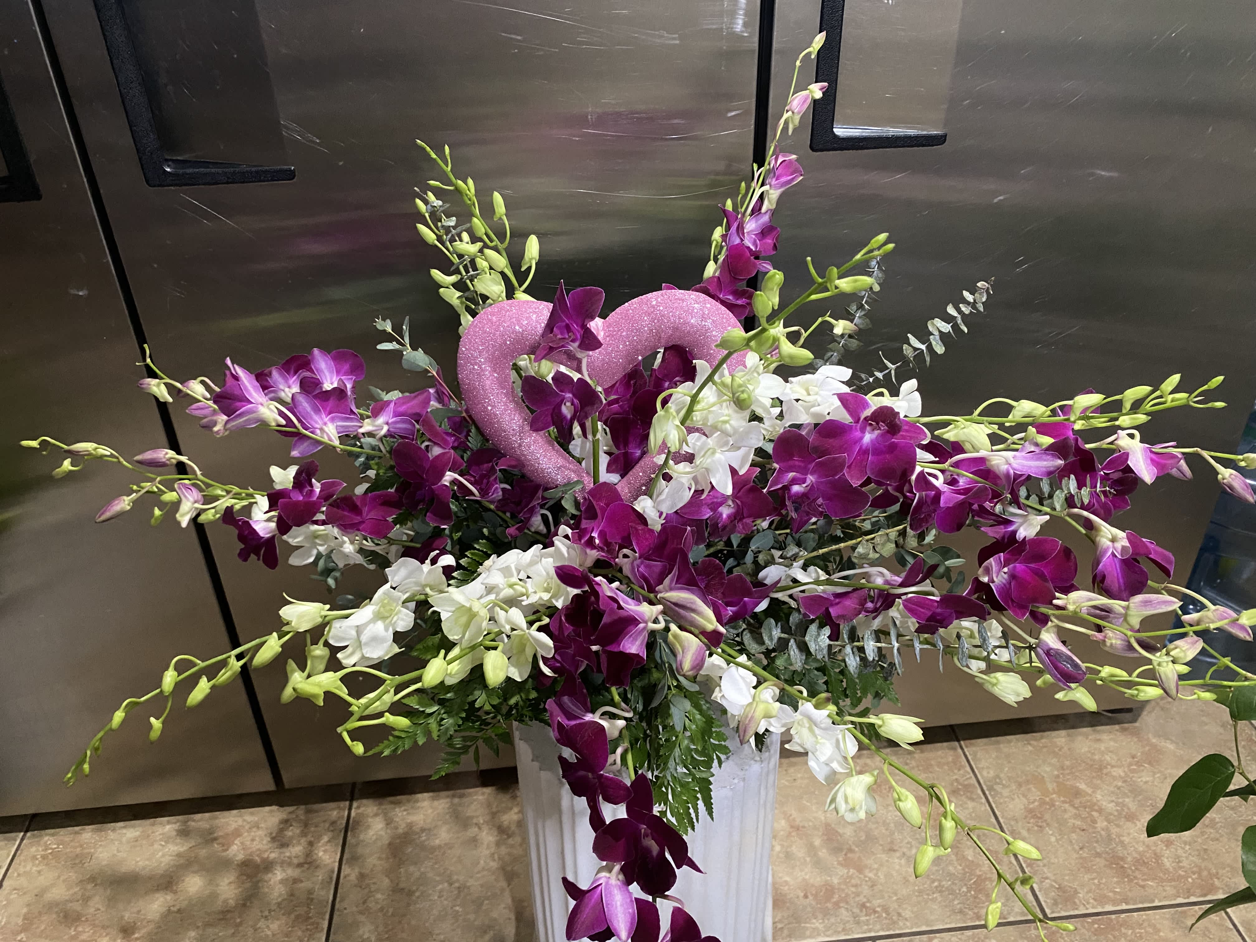 Orchid explosion.   - 20 stems of Purple and white dendrobian orchids in a pretty silver pedestal container