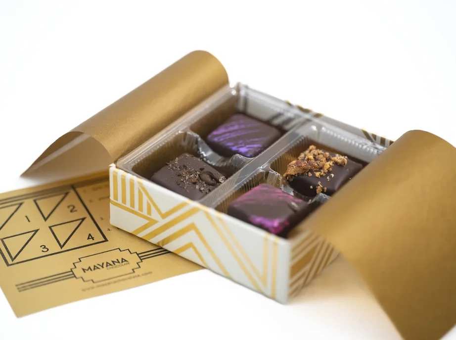 Mayana 4 Piece Luxury Box - This elegant ivory and gold box contains four of Mayana's best-selling bonbons. Treat yourself or that special someone to a decadent chocolate experience.