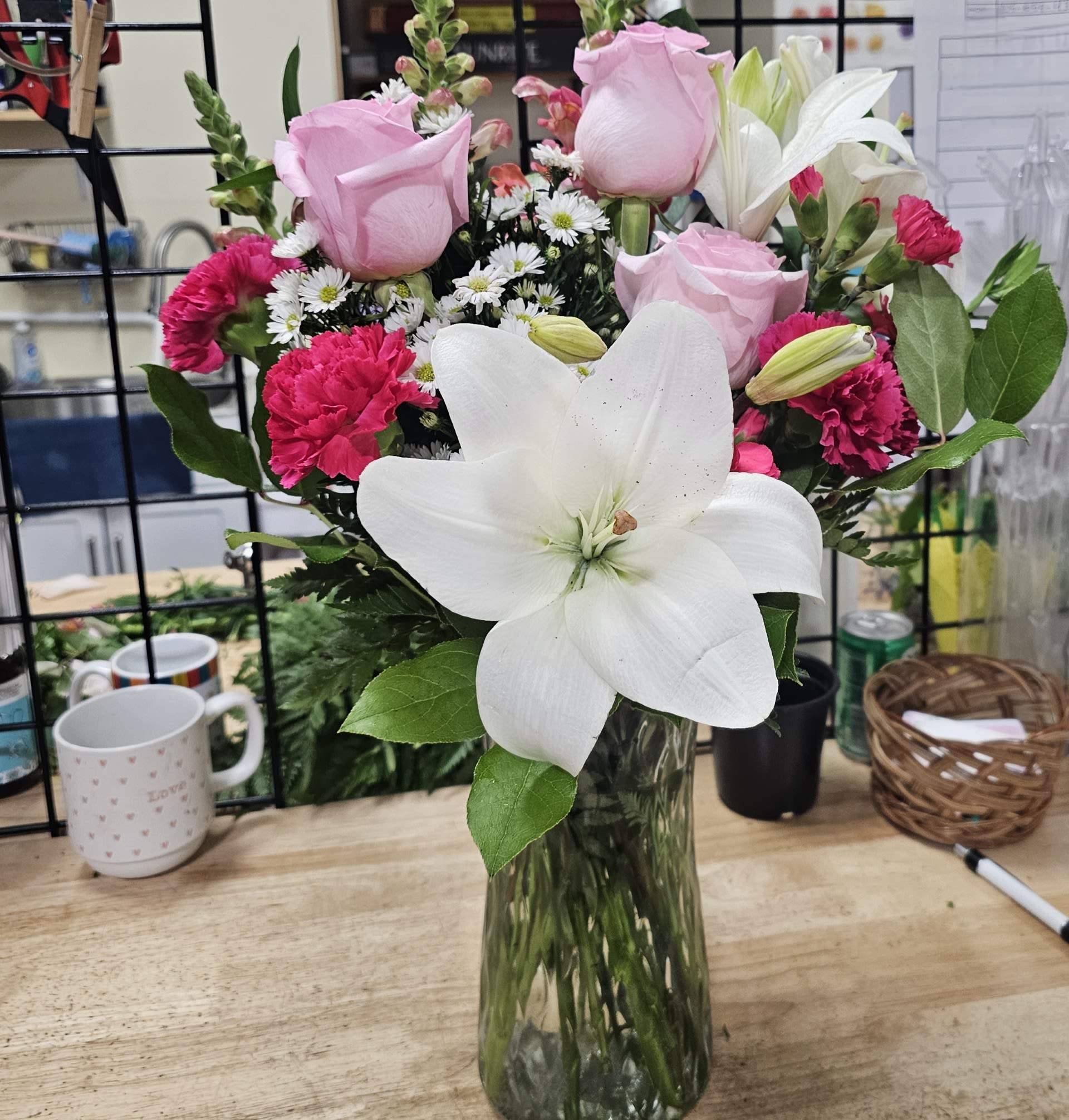 Sealed with a Kiss - A beautiful way to express yourself, sealed with a kiss!  White lilies, pink roses, hot pink carnations, pink mini carnations, white monte casino, pink snapdragons and leather leaf in a clear glass vase.  Pretty well does the job!