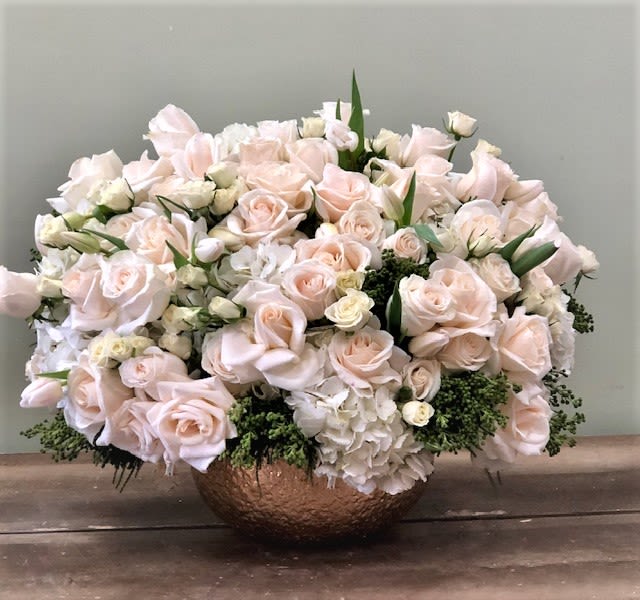 Soft Blush Flower Arrangement  - An elegant arrangement in soft blush and ivory tones styled in a low decorative bowl. Light, airy, and refined, this design features lush blooms layered with subtle greenery for added texture and depth. Its balanced shape and soft color palette create a timeless, sophisticated look perfect for both special occasions and everyday elegance.  Same-day Valentine’s delivery available. Deliveries are made throughout the day based on routing.  Available Sizes: Deluxe Premium      Some florals are seasonal, if a particular flower will not be available due to season, we will substitute for similar flower, composition, color pallet and value of the arrangements as closely as possible. All effort to create a floral arrangement as close to the photo shown, the actual arrangement may vary slightly in its appearance from the photo shown. If you have any questions about your order, we welcome you to call us in or email  