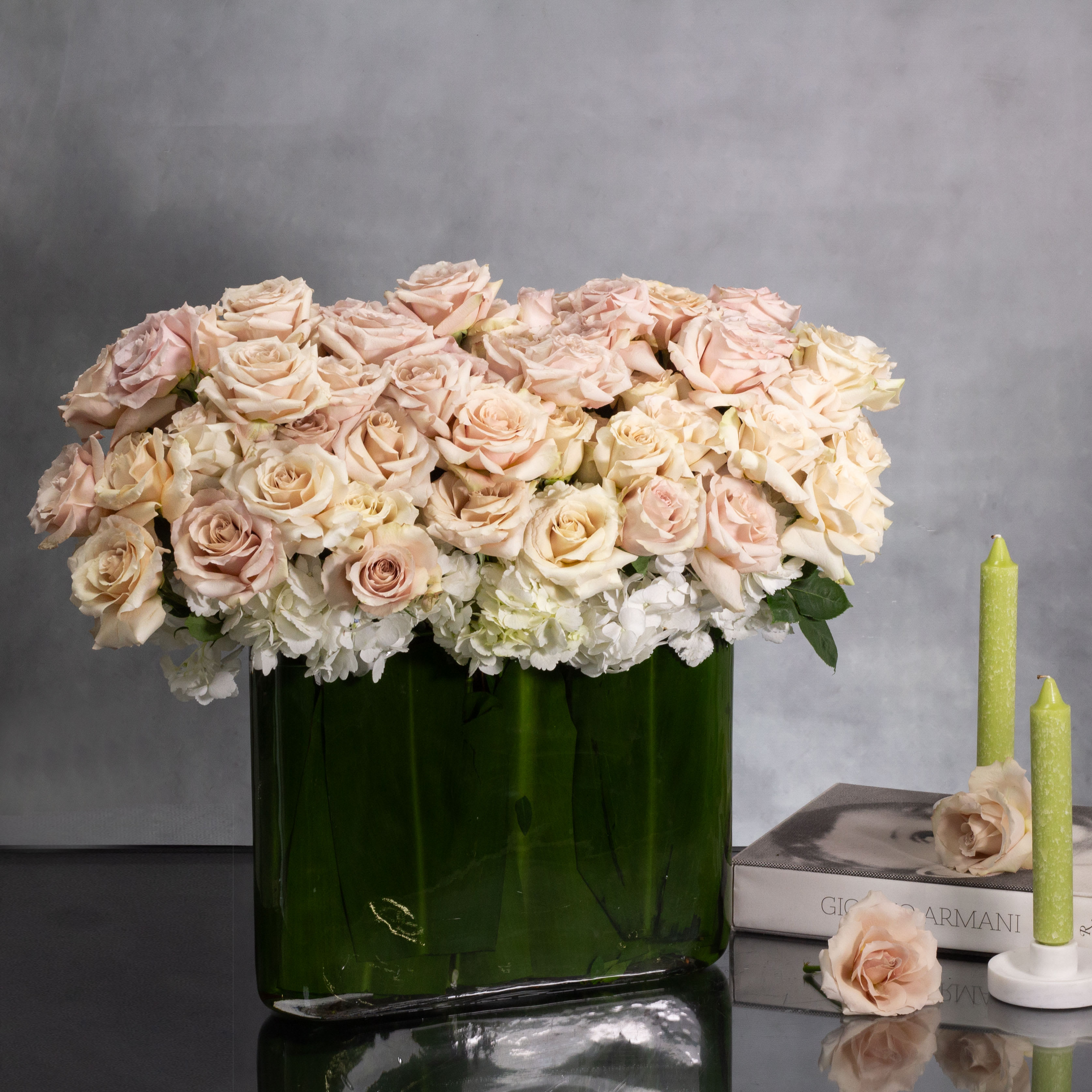Blush Blossom Elegance - Indulge in the serene beauty of our 'Blush Hydrangea Delight' arrangement. Delicately arranged within a sleek, leaf-lined glass vase, soft hues of beige and light pink hydrangeas intertwine, creating an enchanting display of elegance and tranquility. Perfect for adding a touch of sophisticated charm to any space.