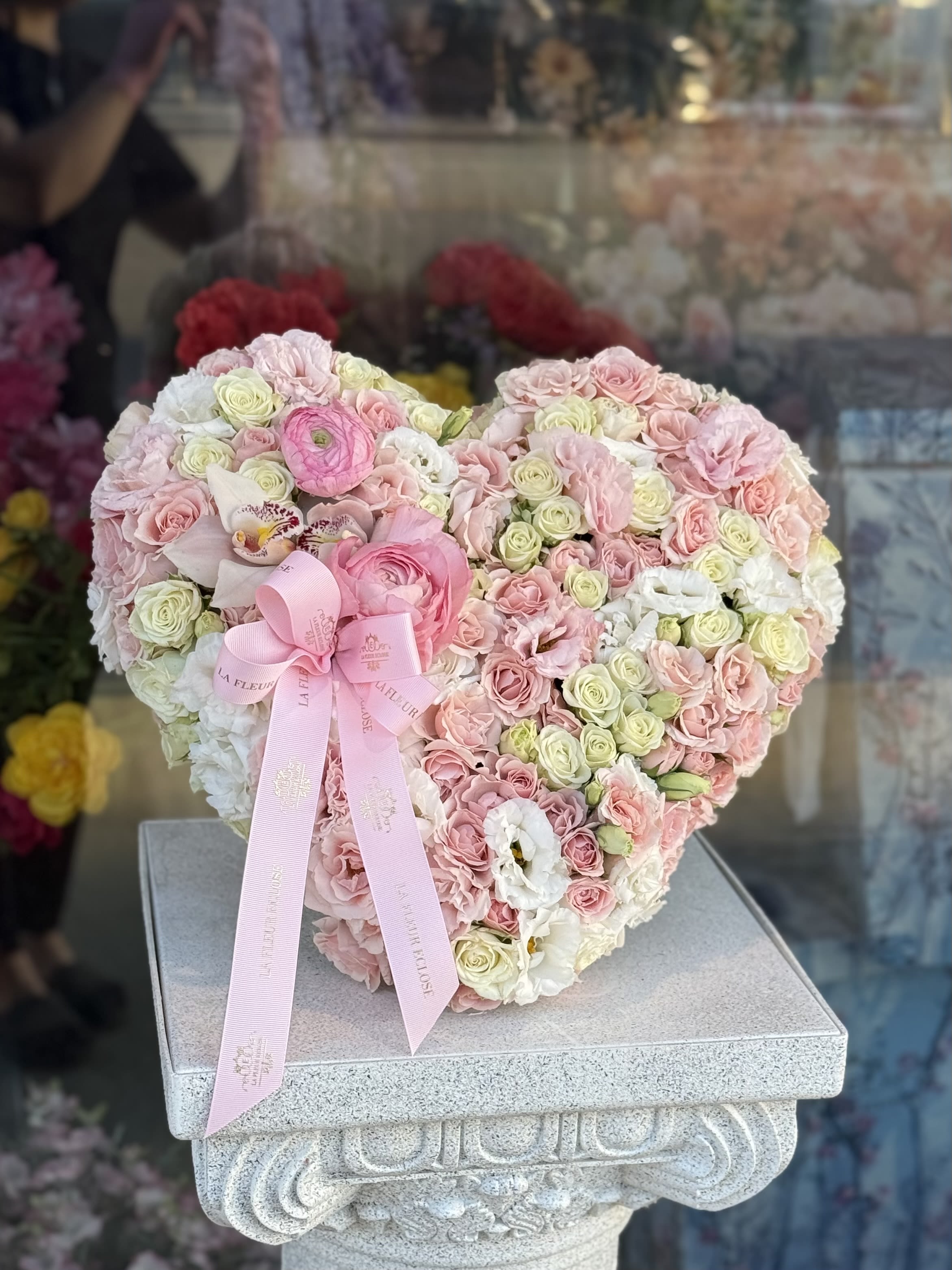 MINI Heart of Elegance V - Discover the magic of blooming elegance with La Coeur Éclatant — a luxurious heart-shaped arrangement of fresh roses and delicate blooms. 1,2 Feet This exquisite bouquet is masterfully crafted to express love, passion, and sophistication. Perfectly nestled in our signature La Fleur Éclose box, it transforms any moment into a celebration of beauty and emotion.  Whether it’s a romantic gesture, an anniversary, or simply a way to say “I love you,” La Coeur Éclatant is a statement of timeless elegance and heartfelt affection.  Perfect for: 	•	Anniversaries 	•	Valentine’s Day 	•	Weddings 	•	Special celebrations