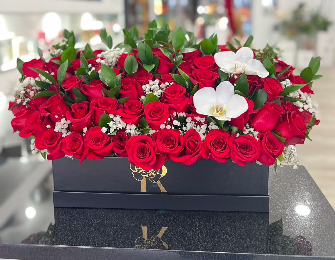 Rozellas "Long Box" - Long Box with red roses, baby's breath and greenery.