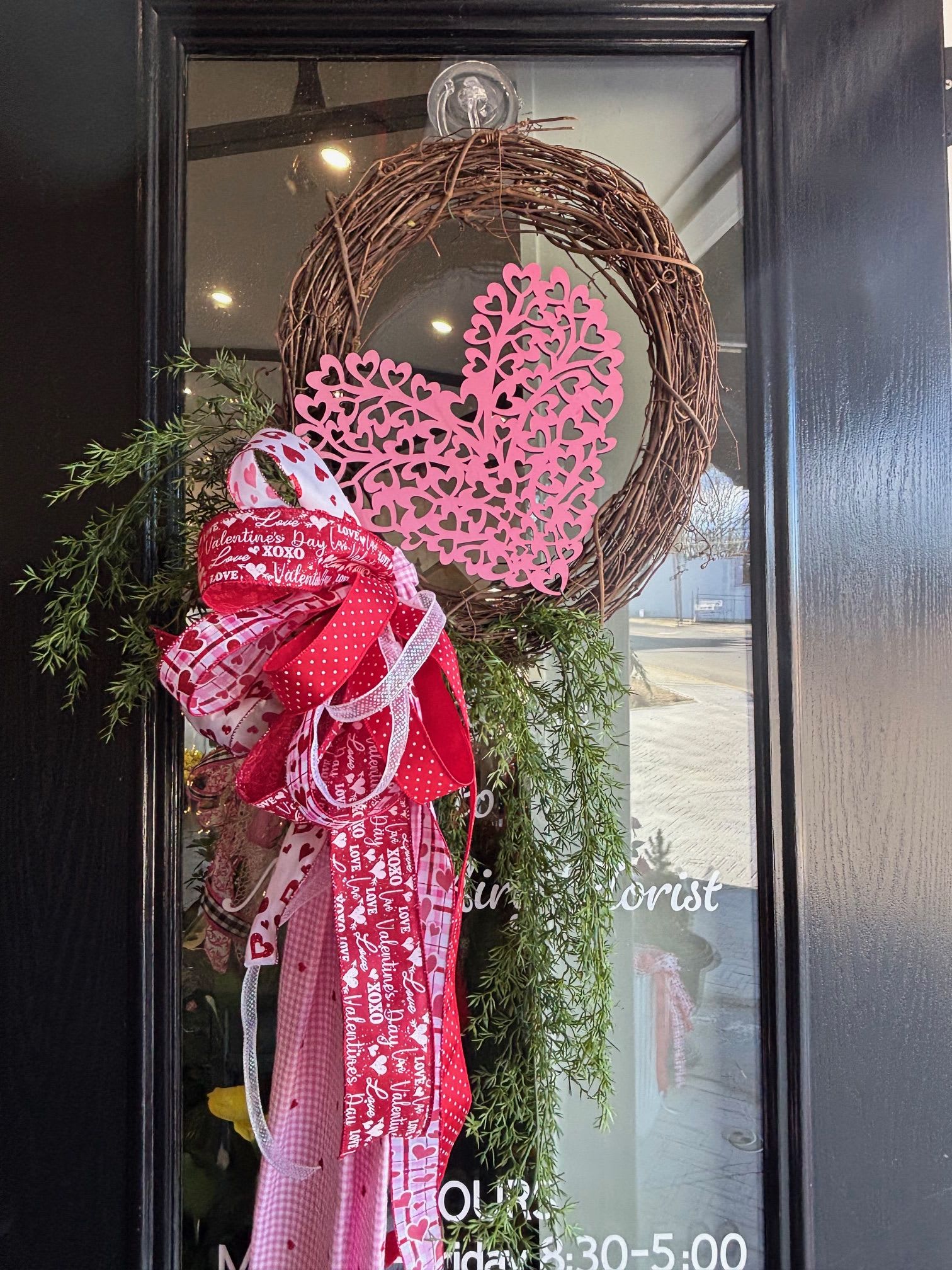 Sweetheart Grapevine Wreath - A charming grapevine wreath adorned with draping greenery, a pink heart, and a festive Valentine’s bow — perfect for a warm and romantic touch to any space.