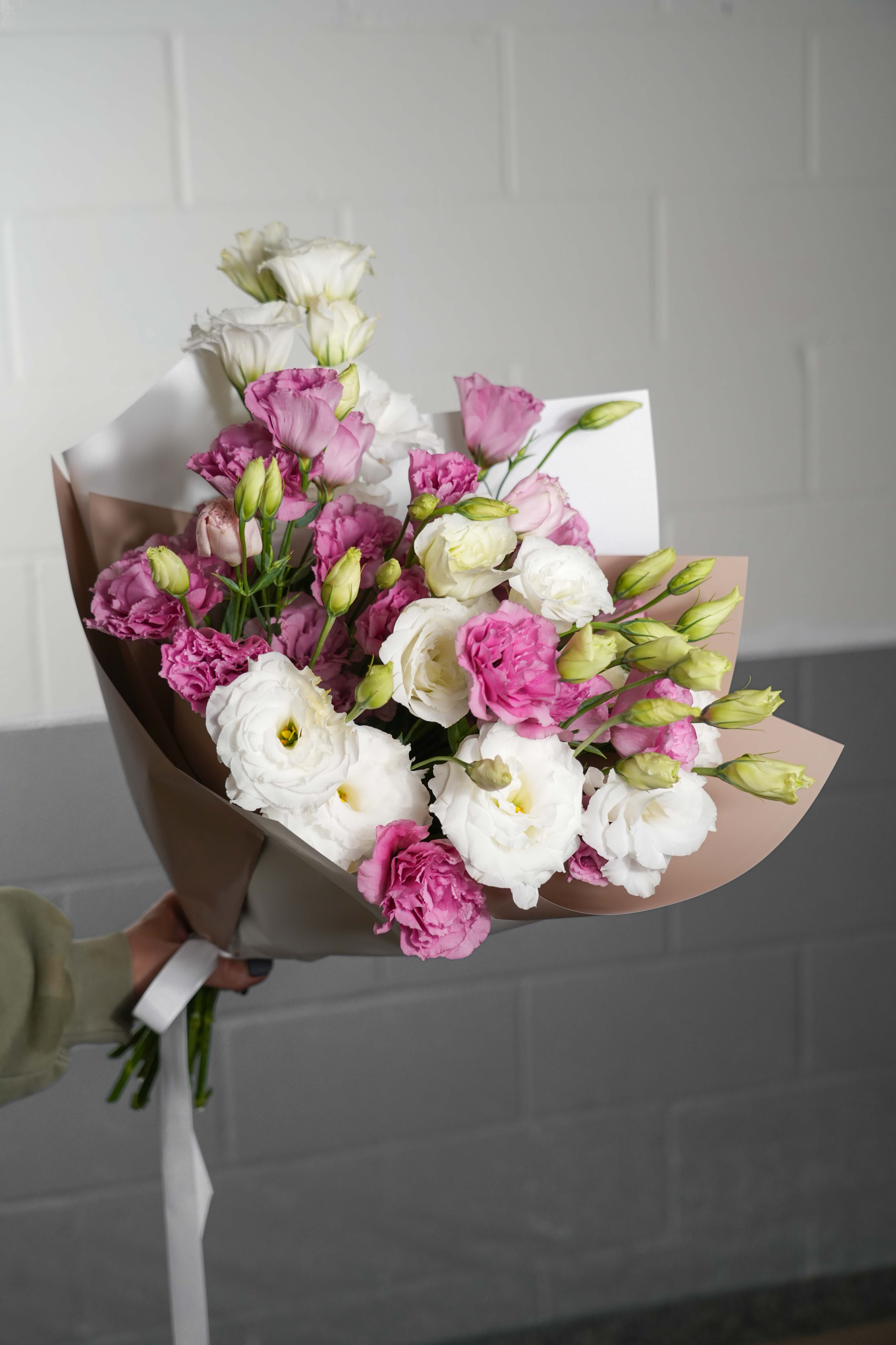 Blushing Serenity Bouquet - The Blushing Serenity Bouquet is a charming arrangement featuring delicate white and pink flowers, artistically wrapped in elegant white and beige paper. This bouquet exudes a sense of calm and sophistication, making it a perfect gift for expressing heartfelt emotions or adding a touch of grace to any setting. Whether celebrating a special occasion or simply brightening someone's day, the Blushing Serenity Bouquet is a delightful choice.