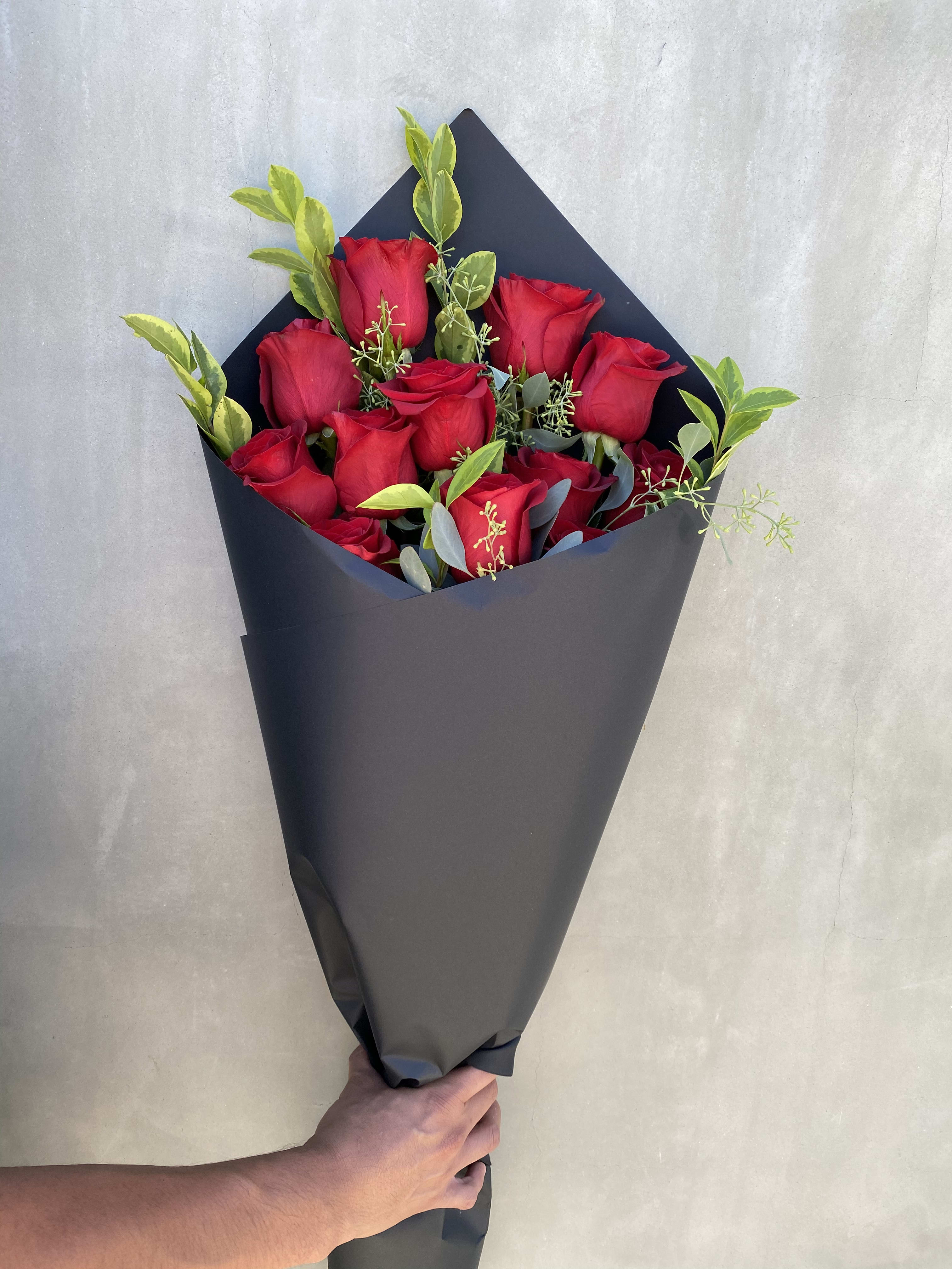 Just Because  - Lovely long stem red rose with greenery wrapped in our limited black paper. 