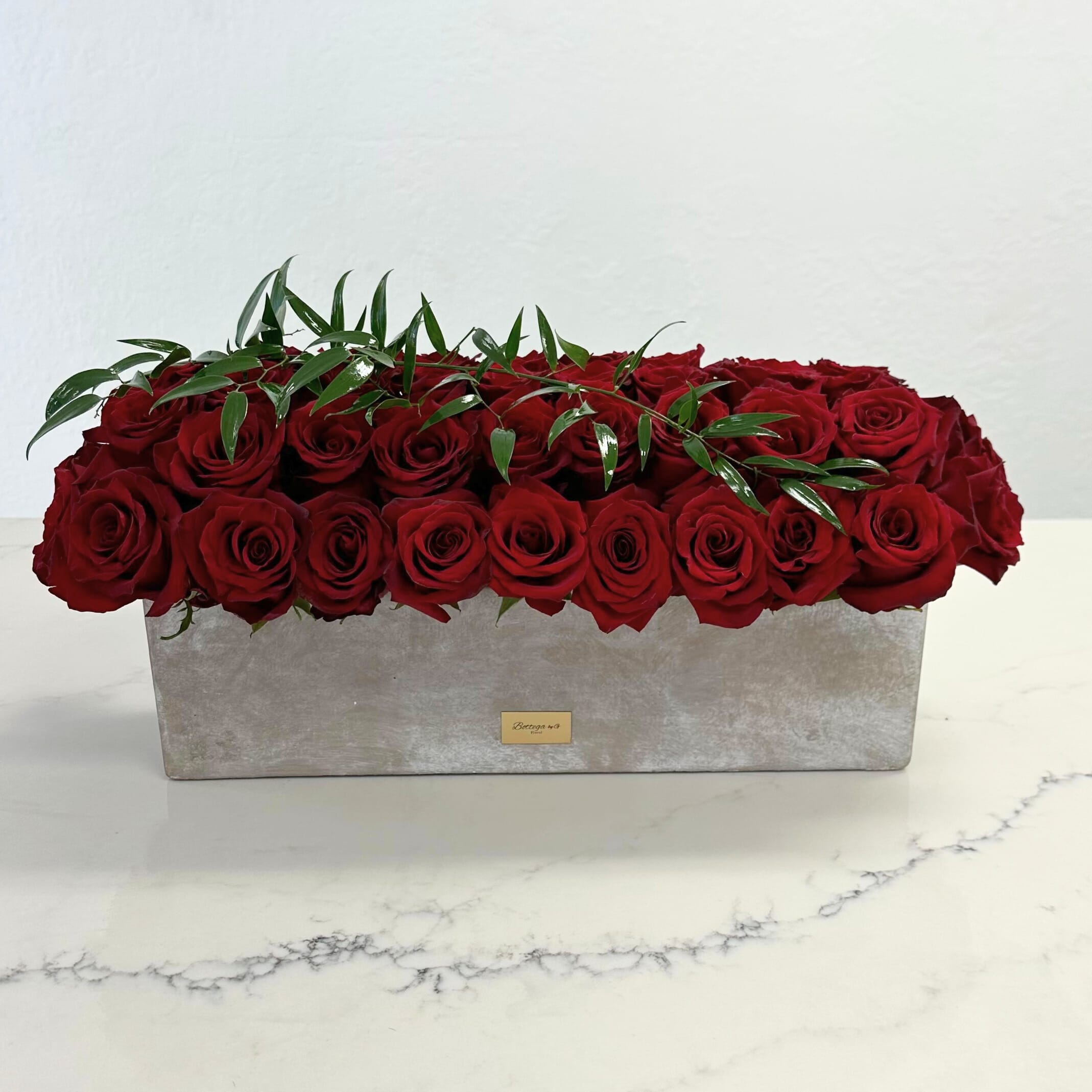 Someone Special - Red roses filled in a rectangular ceramic clay vase.