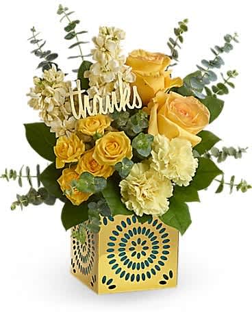 Teleflora's Shimmer Of Thanks Bouquet - Make your appreciation shine! This stylish gift of yellow blooms, hand-delivered in a shimmering metallic cube with unique cutout designs, will make their heart glow. Later, they can remove the teal liner and "thanks" pick and use the cube as a chic candleholder! This cheerful arrangement features yellow roses, yellow spray roses, light yellow stock, light yellow carnations, spiral eucalyptus and lemon leaf. Delivered in a Celebrate in Style cube.