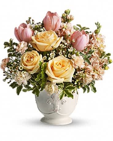 Teleflora's Peaches and Dreams - The only thing sweeter than peaches and cream just might be this dreamy bouquet of delicious roses and tulips. Be a peach and send one today! Pretty in peach roses, tulips, miniature carnations and stock along with white waxflower and fresh spring greens are beautifully arranged in a ceramic French country container.