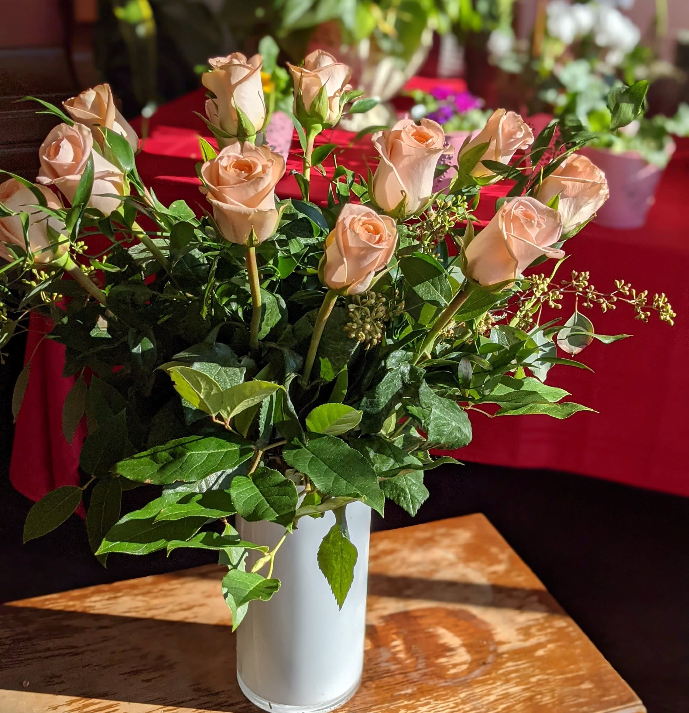 Peach Roses in a Vase - A timeless classic, send a dozen roses in a vase with complementing greenery. Also available in a dozen and a half and two dozen options, just select Deluxe or Premium respectively.  