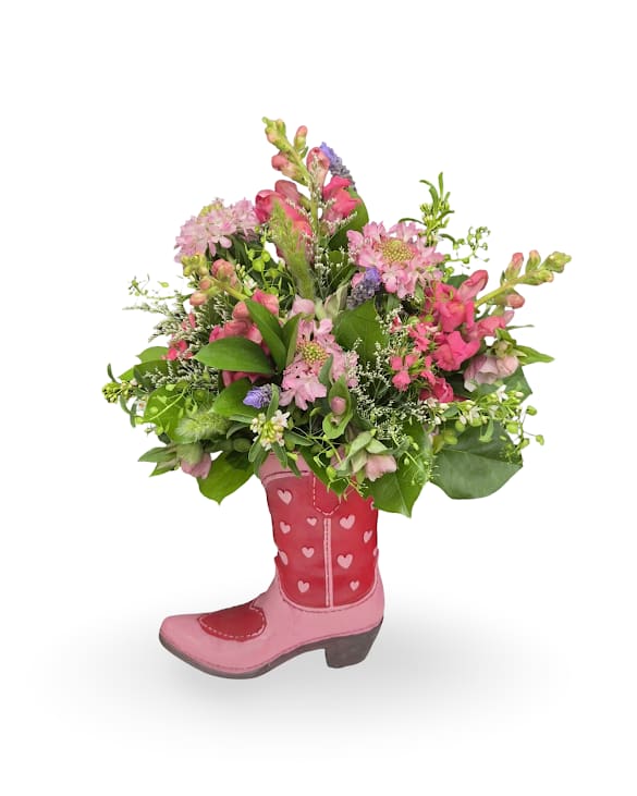 Western Sweetheart - Western Sweetheart is a charming, country-inspired arrangement filled with soft pink blooms, delicate textures, and fresh greenery, all styled in a keepsake cowboy boot vase. Playful yet romantic, this design brings a touch of western flair with a sweet twist. Measuring approximately 17 x 11 x 6 inches, it’s a fun and memorable gift that’s sure to stand out.