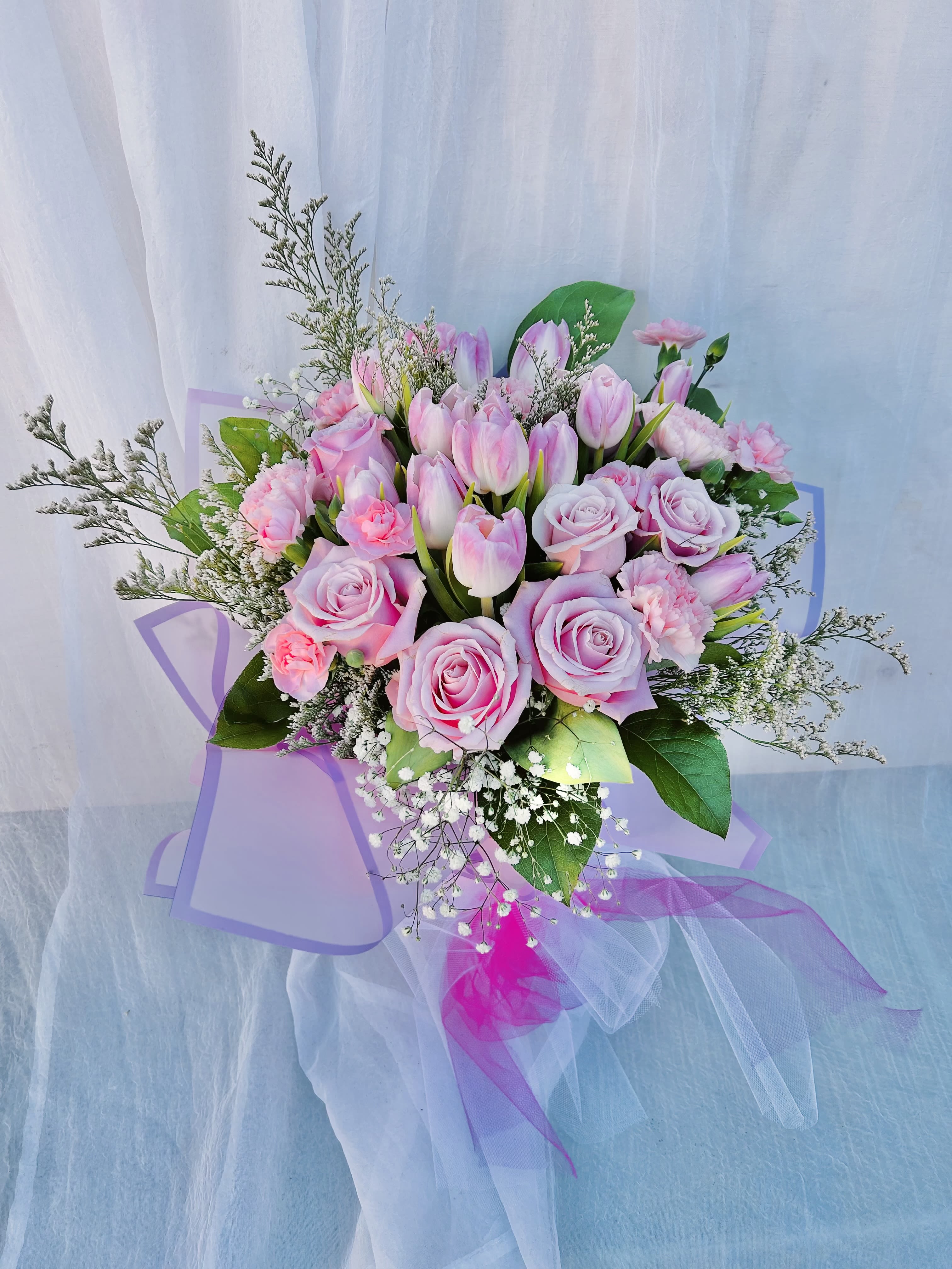 Fairy Tale - Beautiful pink bouquet featuring pink tulips, roses, carnations, baby breathe, and green accents.