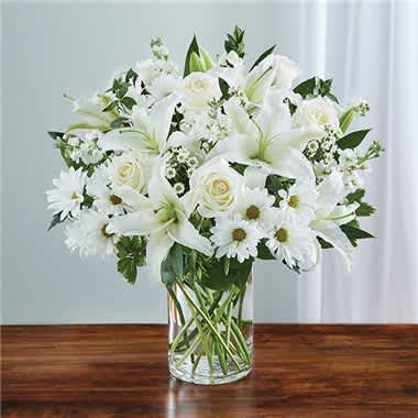 Sincerest Sorrow™ All White - Express your sincere condolences with our elegant all-white arrangement of roses, lilies, stock, daisy poms and monte casino. A peaceful tribute that offers treasured memories of loved ones. � Abundant bouquet of the freshest white roses, lilies, stock, daisy poms and monte casino, accented with variegated pittosporum, salal and myrtle � Hand-designed by our expert florists in a classic glass cylinder vase; vase measures 8"H � Can be sent to the home of friends, family members or business associates, or to the funeral service � Large arrangement measures approximately 24"H x 22"L � Medium arrangement measures approximately 22"H x 20"L � Small arrangement measures approximately 20"H x 18"L � Our florists hand-design each arrangement, so colors, varieties, and container may vary due to local availability � Lilies may arrive in bud form and will open to full beauty over the next 2-3 days