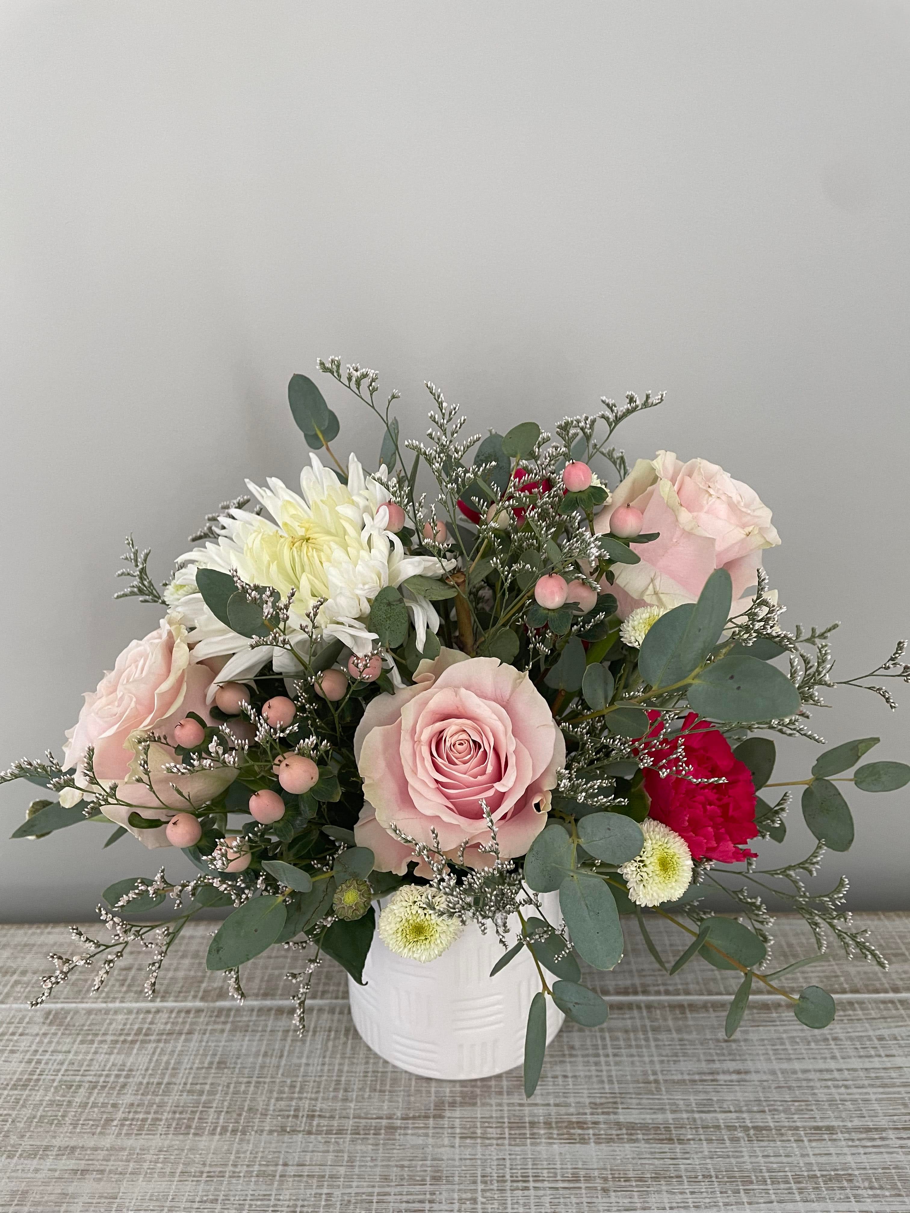 Sweet Centerpiece - A modern and simple arrangement of roses, mums and carnations. Flower color and vase will vary.