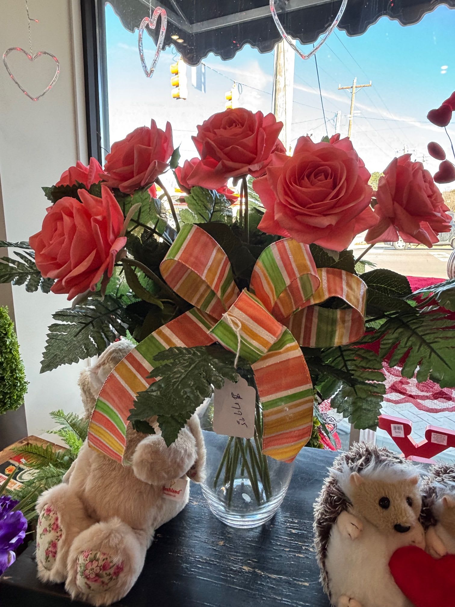 One dozen artificial peach roses - A dozen peach artificial roses beautifully arranged in a clear glass vase — a soft and elegant accent that lasts.