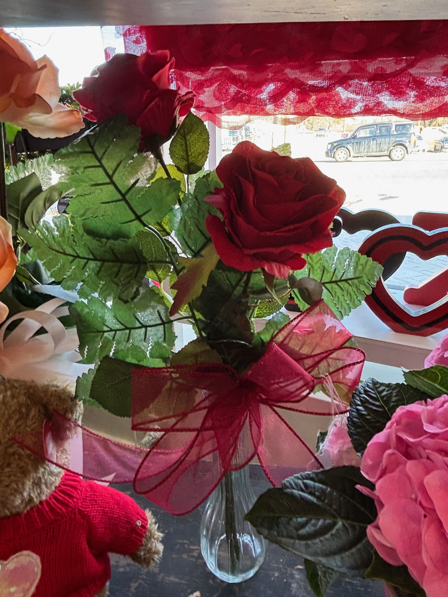 2 artificial red rose budvase - A pair of red artificial roses in a simple bud vase, perfect for a timeless and elegant touch.