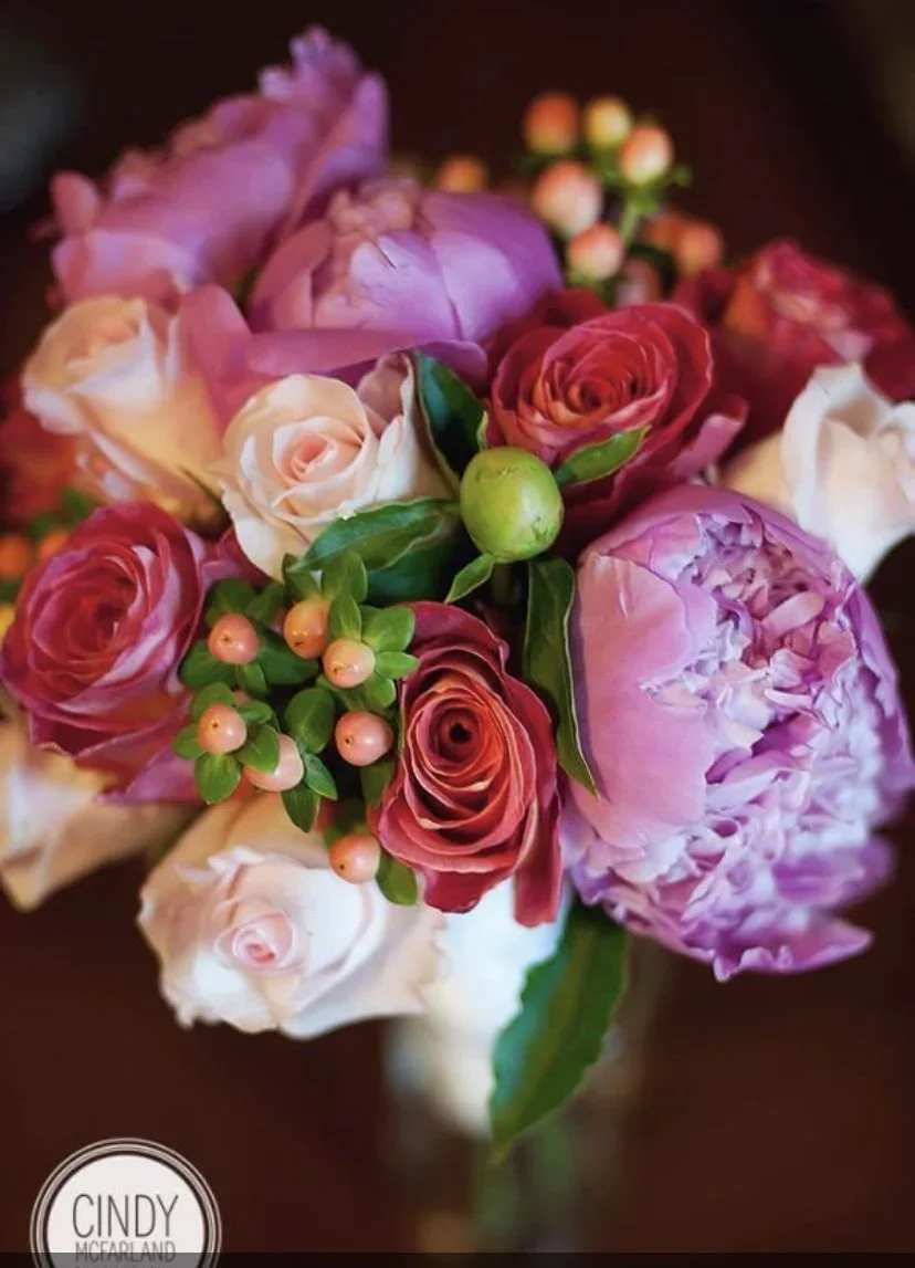 Love Me Do - A compact arrangement of roses, berries and other seasonal blooms in feminine colors.