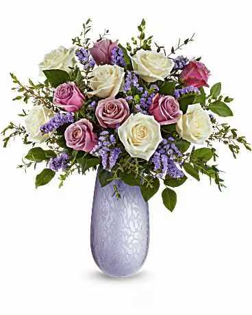 Teleflora's Marvelous Moments Bouquet - Make every moment magical with the Marvelous Moments Bouquet, a breathtaking all-rose arrangement in the hand-blown iridescent Vivi vase. Radiating romance and elegance, this timeless keepsake is the perfect way to celebrate love in style. The Marvelous Moments Bouquet features crème roses, lavender roses, lavender sinuata statice, parvifolia eucalyptus, and salal. Arranged in the hand-blown iridescent Vivi vase, this elegant all-rose bouquet is a timeless expression of love and romance.