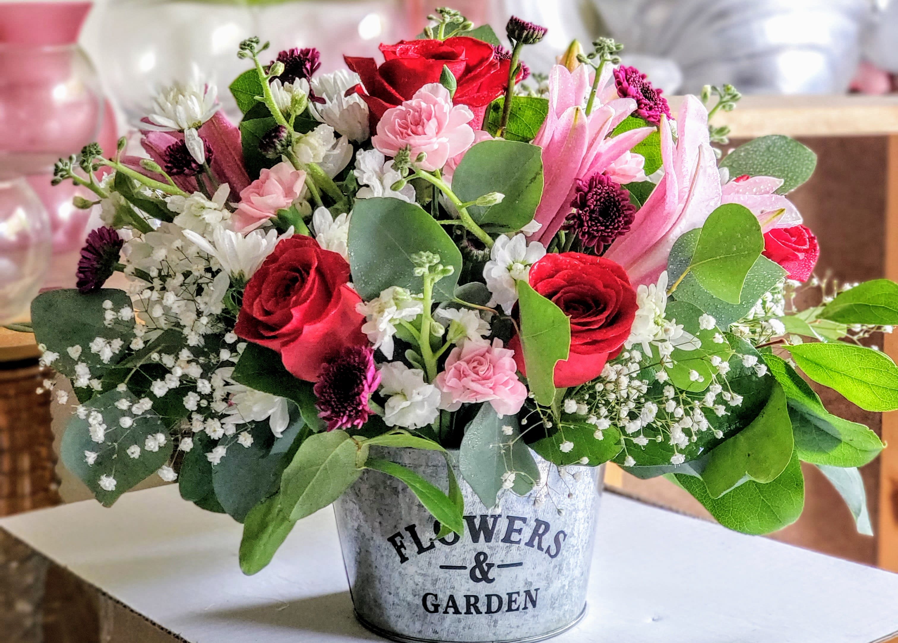 MOM'S Garden  - A lush, unique floral arrangement featuring different blooms in a garden container, perfect for an entrance or a kitchen table.  Flowers may be subject to change based on our inventory; we will substitute with other premium blooms available. Thank you for being so understanding!