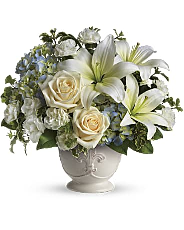 Beautiful Dreams - This French country style sympathy arrangement communicates your condolences in a most heartfelt way. It's a lovely choice when you want to send flowers to family or friends. A beautiful bouquet of blue and white sympathy flowers - blue hydrangeas, crème roses, white miniature carnations, fragrant white asiatic lilies and green pitta negra - are delivered in a French Country Pot. Orientation: All-Around
