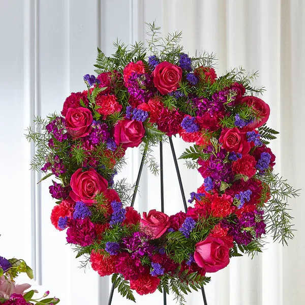 Calming Colors Wreath - The use of color in a sympathy tribute can evoke emotions that words otherwise can’t. In our Calming Colors Wreath, a gorgeous display of bold pinks and comforting purples come together in a timeless expression of sympathy. This arrangement comes expertly crafted by our artisan designers with stock, roses and carnations to show how much you care.  Details Wreath is approximately 22" diameter. Designed by florists, ready to display. Pet Safety Precautions: This bouquet or plant may include flowers and foliage that are known to be toxic to pets. To keep them safe, be sure to keep this arrangement out of your pet's reach.