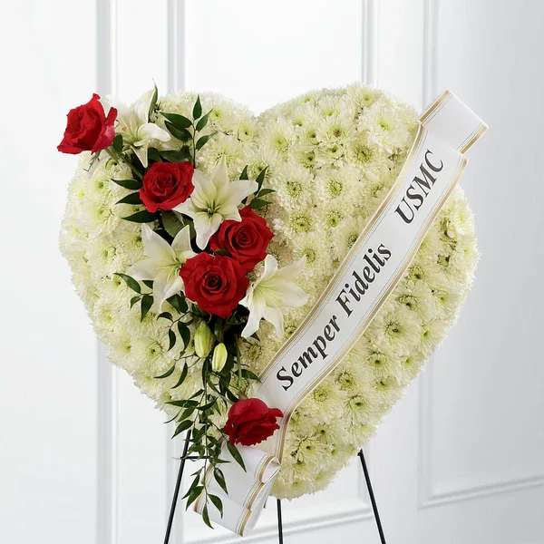 Heartfelt Hero Standing Heart - Express your condolences with an arrangement that beautifully expresses comfort and honor within each bloom. Our Heartfelt Hero Standing Heart is made of a collection of cushion pompons, and accented with roses and lilies. To bring it all together, this breathtaking piece comes personalized with a printed ribbon.  Details 24"h x 24"w