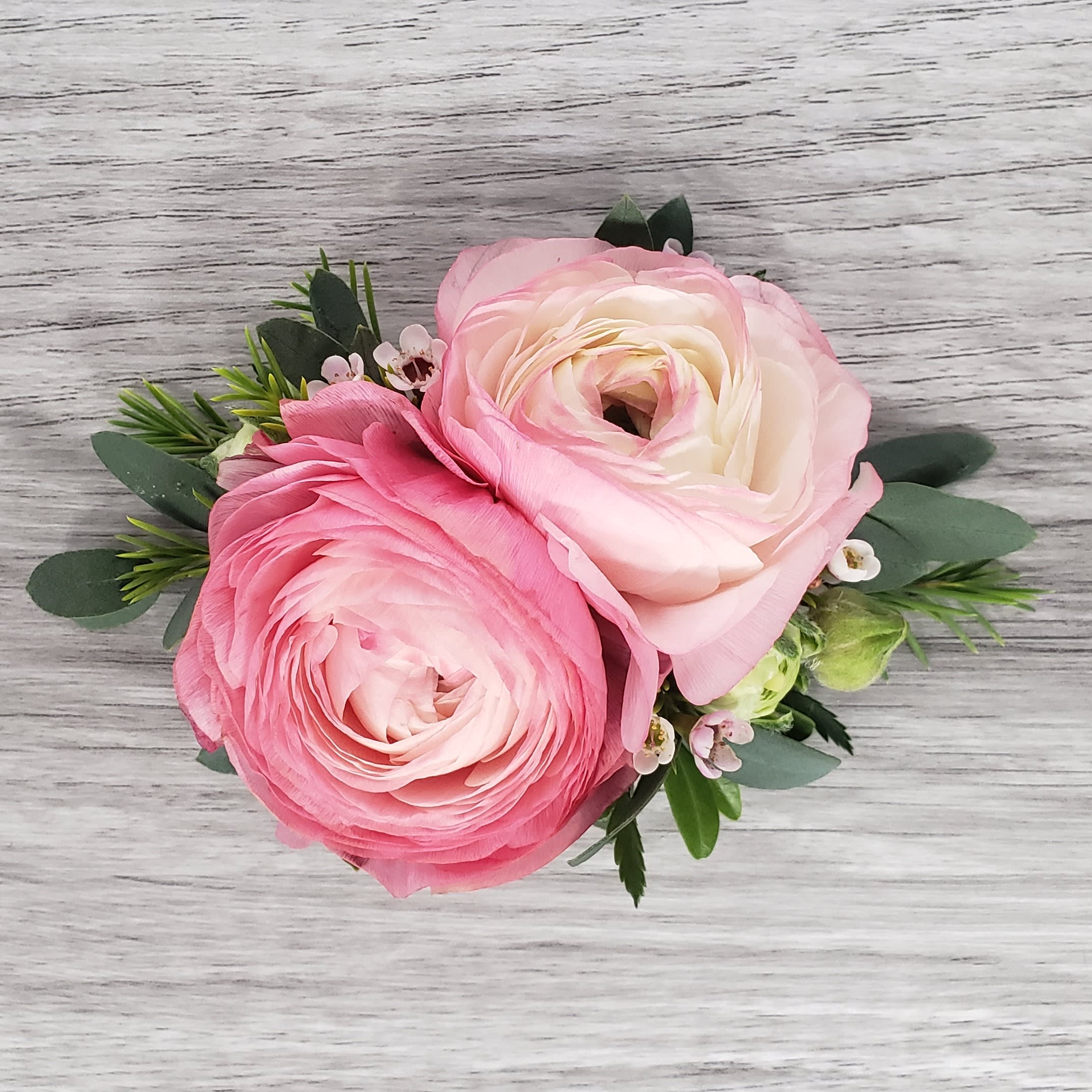 Pink Ranunculus Corsage - This corsage is more petite in size and features light pink ranunculus, and complementary greens and accent flower.If you would like to exchange the colors of the flowers please let us know and we will be happy to accommodate.