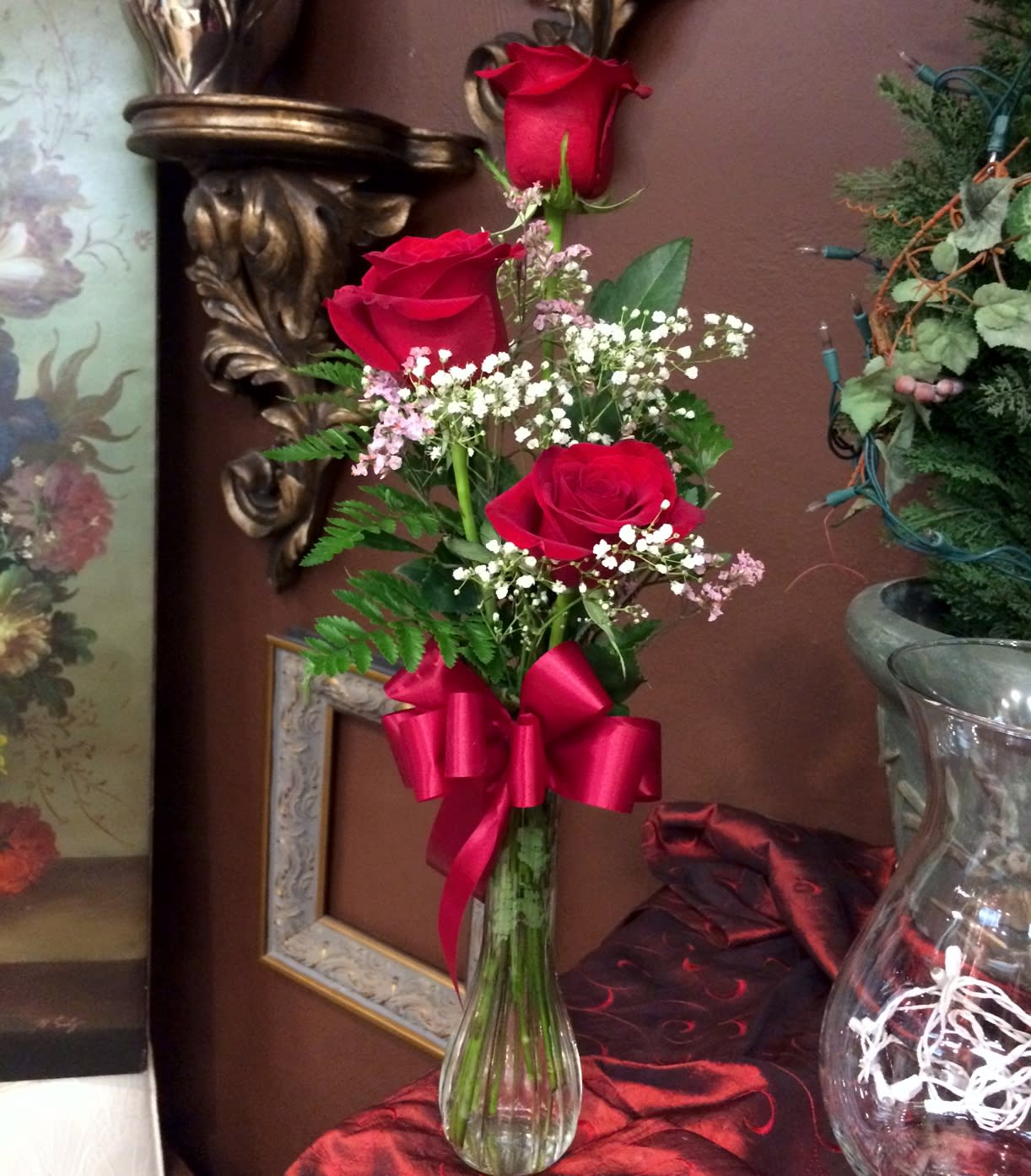 Three's Company - Three beautiful roses in a bud vase with filler flowers, greens, and a bow.   We are proud to deliver our flower creations to the Kenosha, Somers, and Pleasant Prairie area. With over 55 years of combined flower design experience in Kenosha, Wisconsin, A Summer's Garden Florist and Gifts is the perfect choice for the freshest flowers, the most creative design, and exceptional customer service.