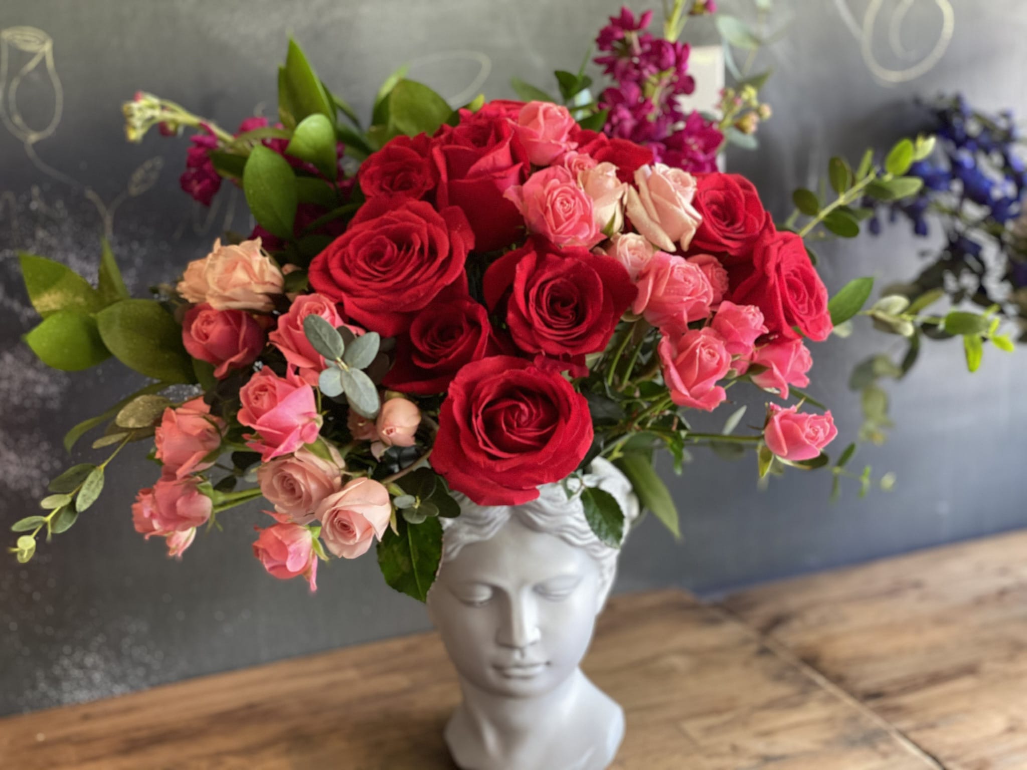 The Aphrodite   - Nothing less than what would be expected from the Goddess of Love! The Aphrodite arrangement features the freshest blooms, including freedom red roses, pink spray roses, eucalyptus, and more. All beautifully arranged in a luxurious vase fit for the goddess herself. Perfect for celebrating love and elegance. Order now for quick and reliable delivery!