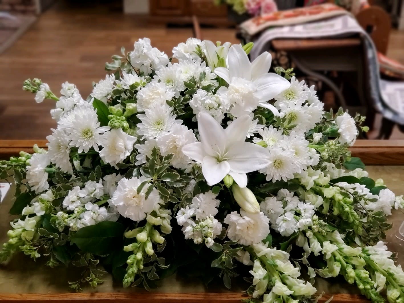 Serene Casket Spray - Half Piece - All white flowers in this half casket spray to include, lilies, snapdragons, stock, chrysanthemums and carnations