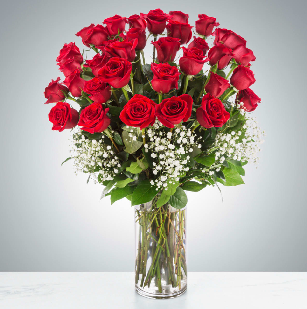 Grandeur Long Stem Rose Arrangement (3 Dozen) - Go big with your love. Send the most extravagant 3 dozen red rose arrangement for Valentine's day, anniversary celebrations, or declarations of love. This luxury arrangement makes a big statement of "I love you" in 36 roses.  Approximate Dimensions: 20"D x 32"H
