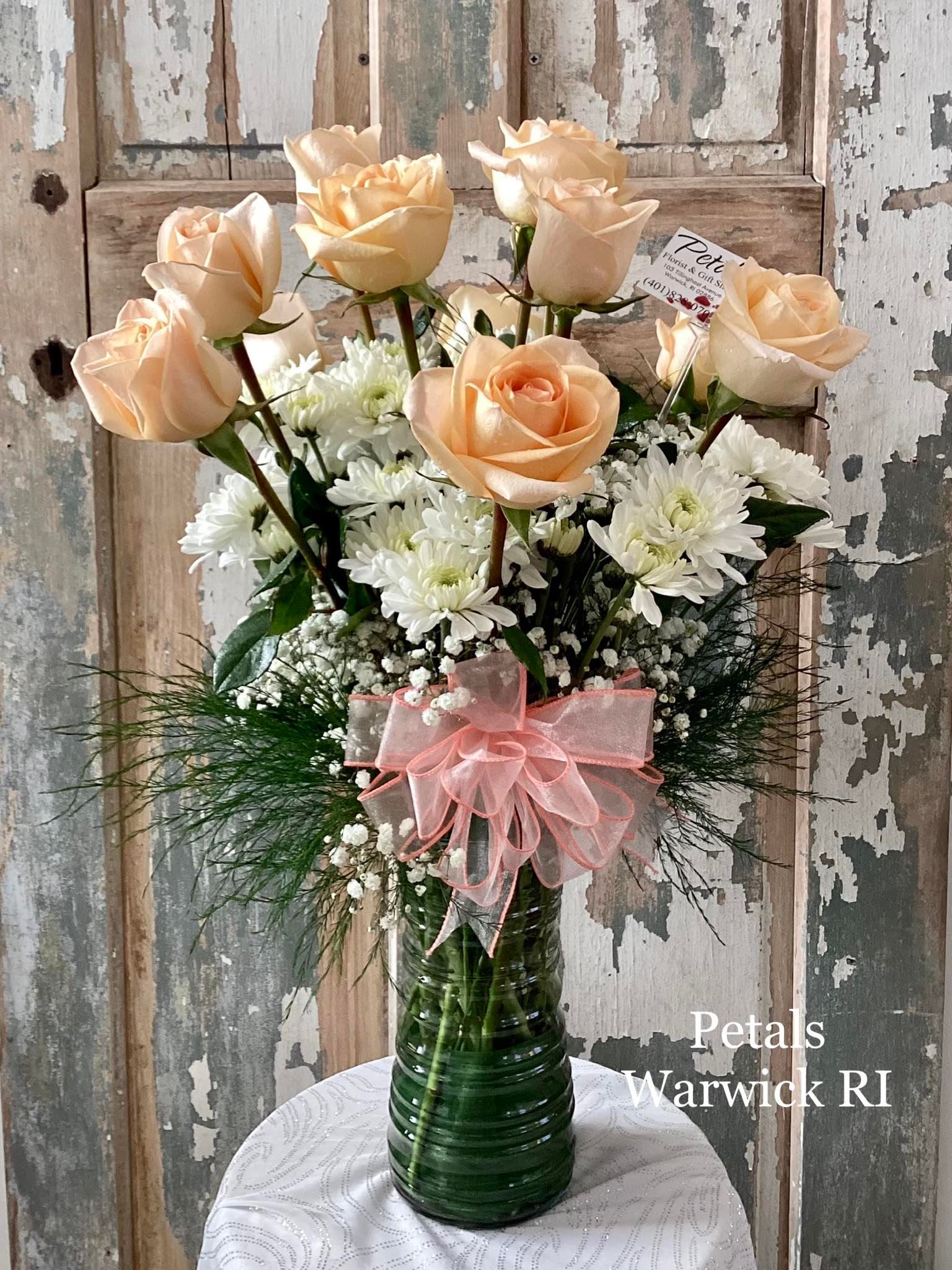 A Perfectly Peachy Dozen w/ The Works by Petals - Peach – Lovely peach roses symbolize sincerity, friendship, gratitude, and genuineness. These Perfectly Peachy Roses will undoubtedly keep a smile on your recipient's face and make a lasting impression.  * on occasion, the rose variety may vary due to daily availability, but the overall feel of the design will remain the same. Feel free to call me directly if you have any questions. 401-828-0701  Thanks,  Cheryl