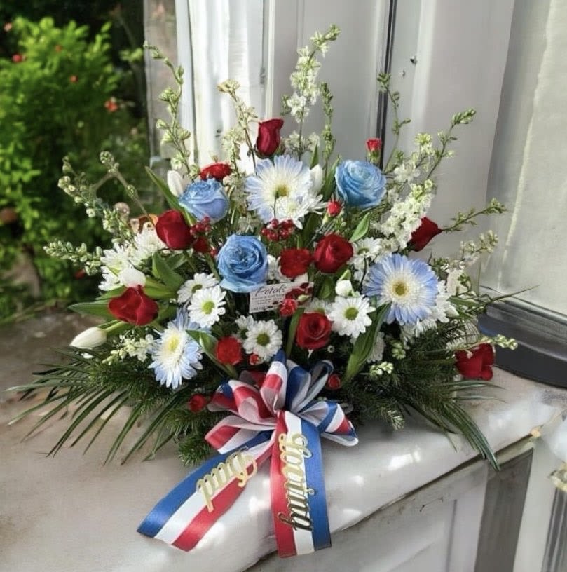 Patriotic Sitting Spray Red White and Blue by Petals -  Honor your loved one who proudly served our Nation with a beautiful Patriotic Sitting Spray for their celebration of life memorial service. Designed to sit flat, the flowers are forward-facing for a showy appearance; it's a medium-sized floral with a beautiful array of Red, White, and Blue Flowers. Some flowers may vary due to supply fluctuations. Please call me at 401-828-0701 if you have a special request. Thank you, Cheryl  Please allow 24 to 48 hours of leeway for this design to be processed. If you need immediate delivery, contact me at 401-828-0701 for a telephone consultation today.