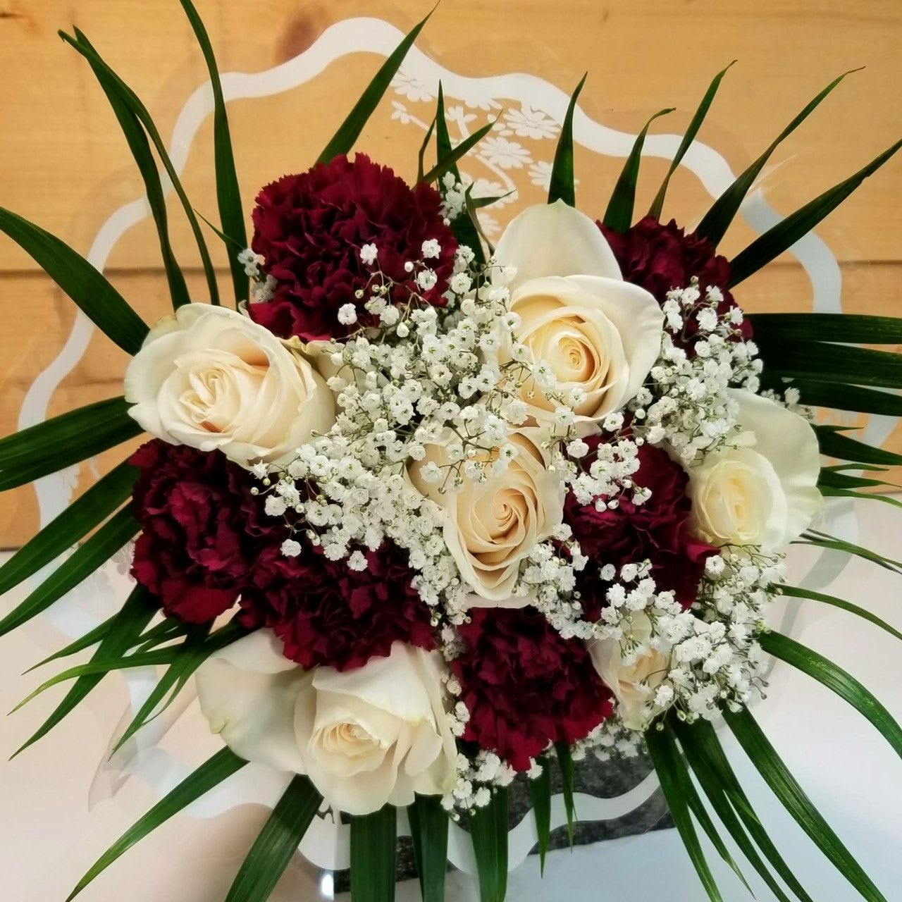GO OP Wrapped Rose &amp; Carnation Bouquet - The GO OP Wrapped Rose &amp; Carnation Bouquet by Savilles Country Florist.  Wrapped bouquet of 6 white roses and 6 maroon carnations accented with babies breath &amp; greens. The perfect way to show off your school spirit!