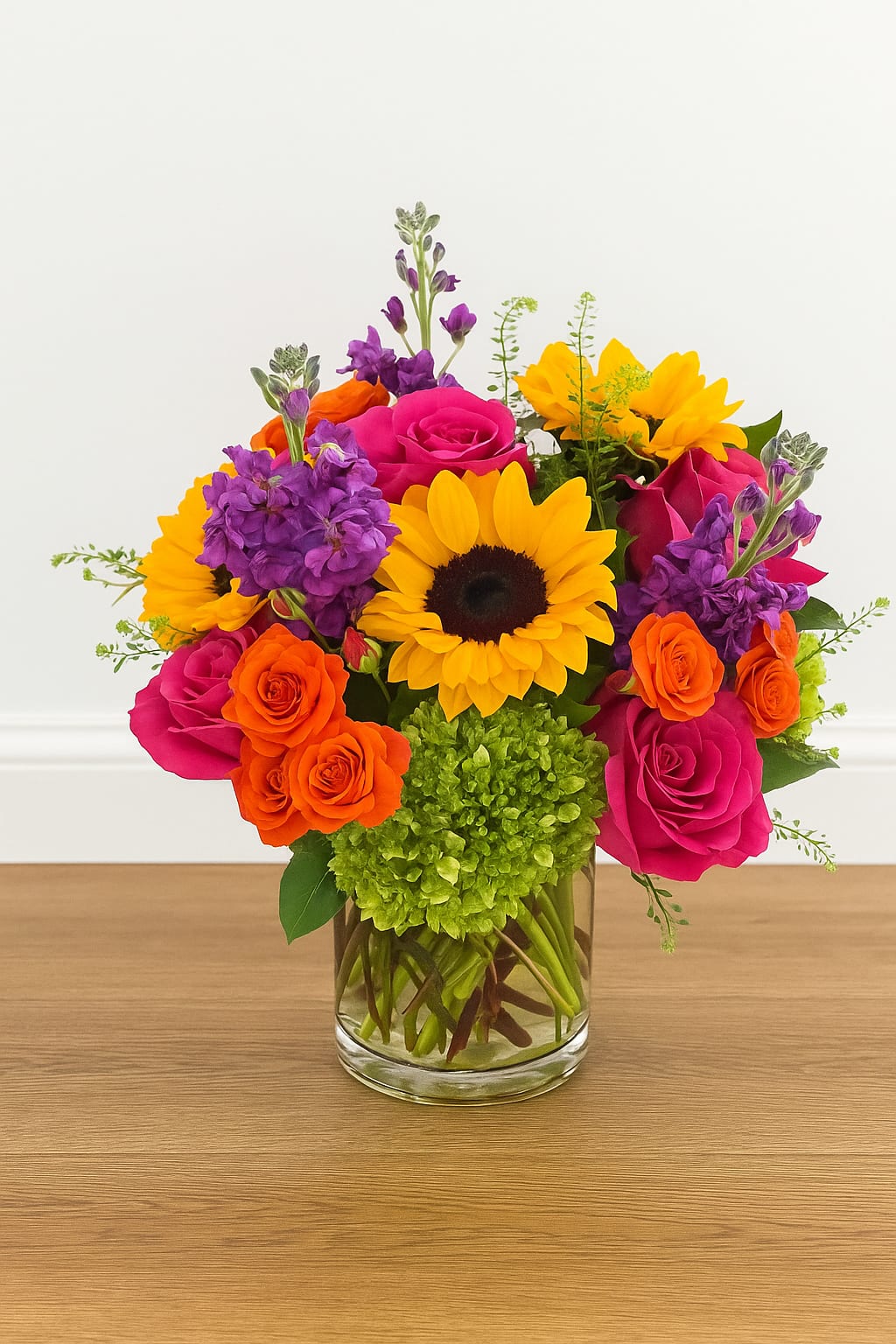 San Francisco Vibes - San Francisco Vibes — A bold and modern flower arrangement bursting with color and personality. Featuring radiant sunflowers, fuchsia roses, orange spray roses, and purple stock, this vibrant bouquet captures the lively spirit of San Francisco. Designed in a sleek glass vase with lush hydrangea accents, it’s perfect for birthdays, celebrations, or simply adding joy to any space. Handcrafted by our San Francisco florist for same-day delivery.