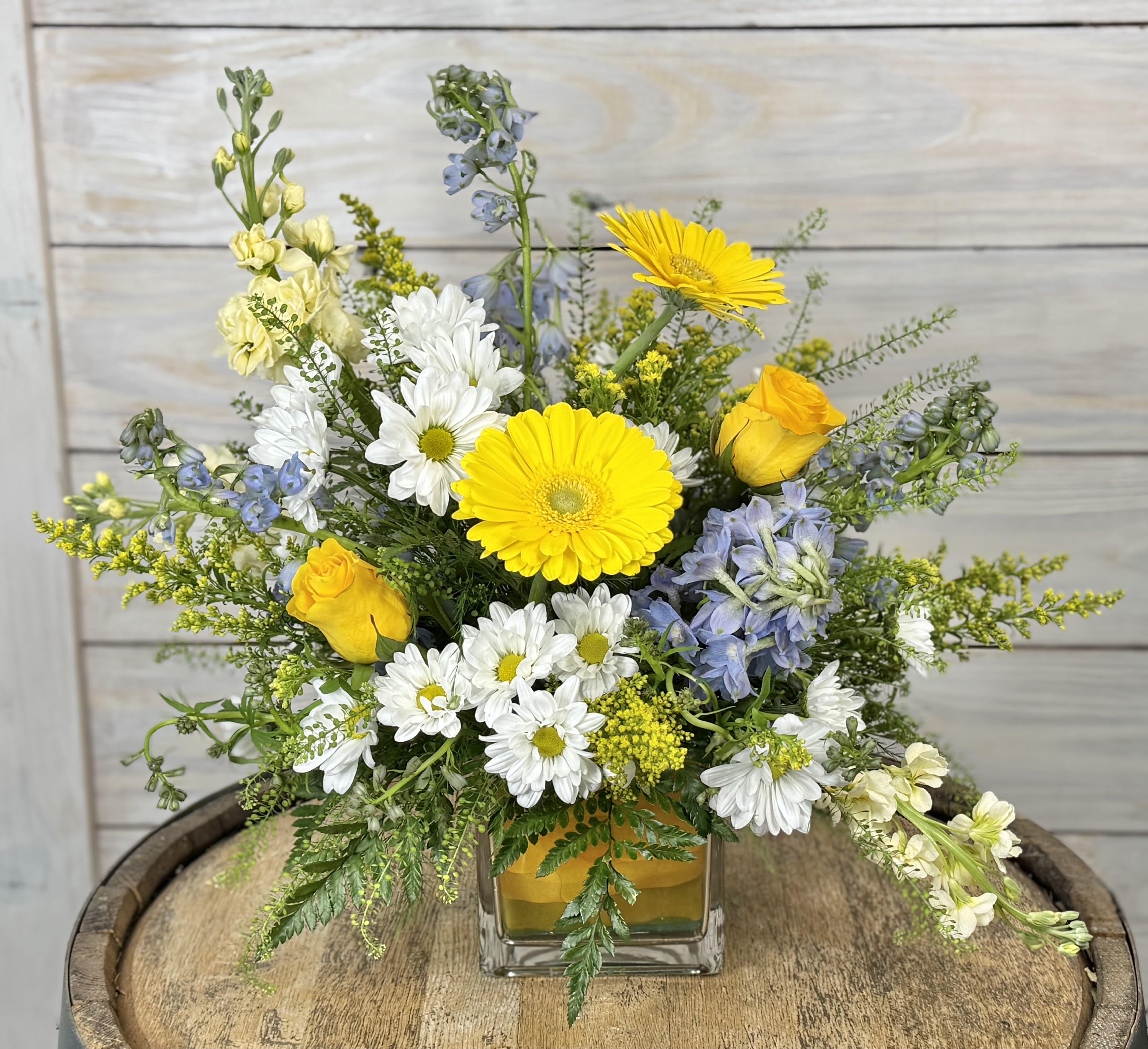 Country Road.... (Take Me Home) - This playful and bright arrangement evokes summertime memories of long drives on back roads with your favorite music crooning in the background. Take this beauty home today!