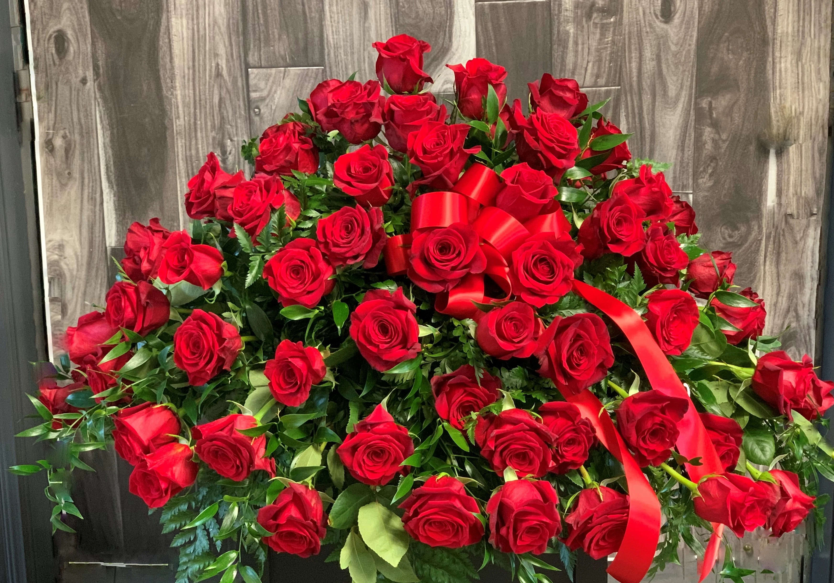 Heavenly Rose Casket Spray - Pay your respects with a divine mix of red roses combined with greenery in this classic casket spray. A lovely way to express hope and sympathy.