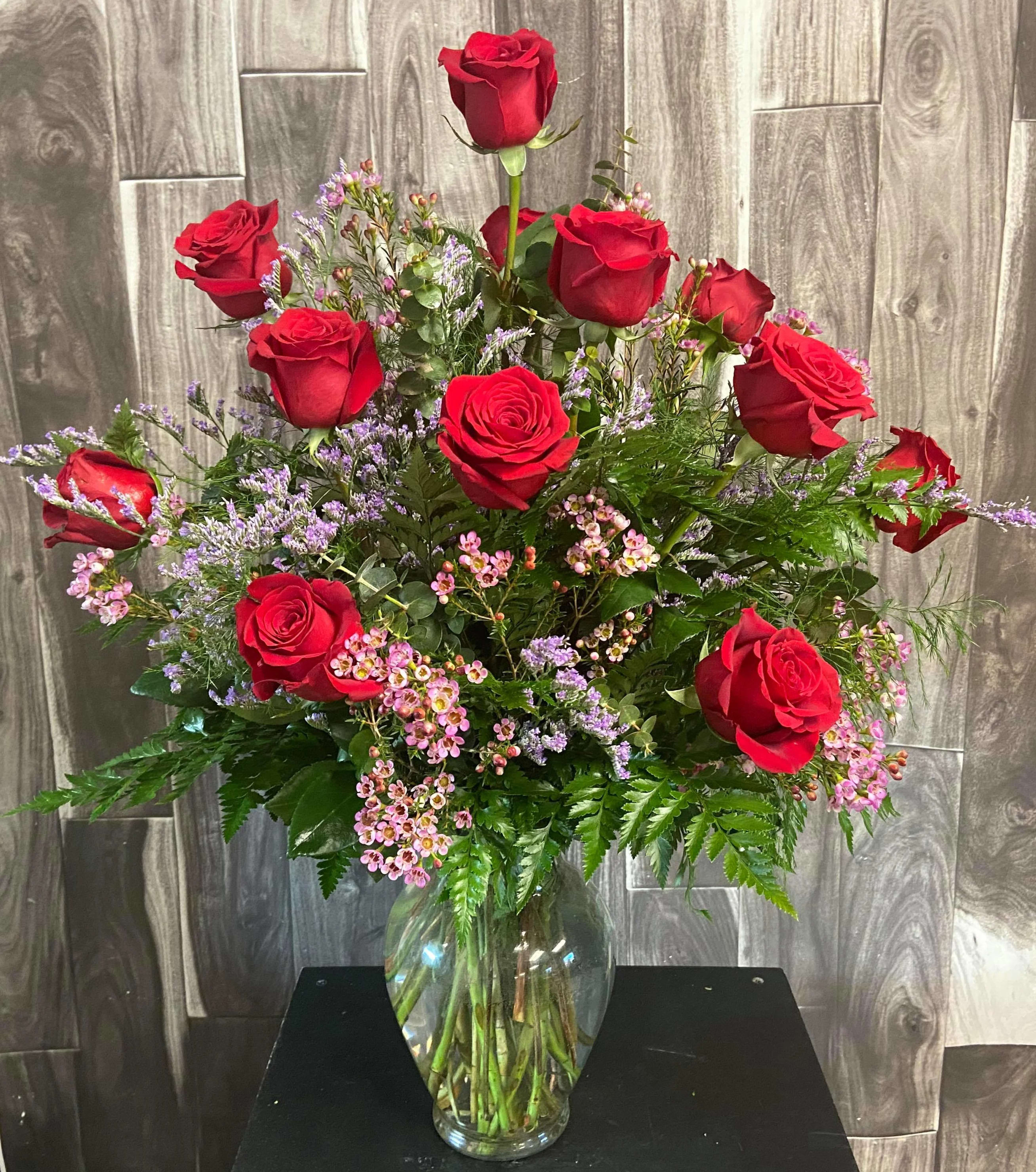 One Dozen Long Stem Red Roses - Beautiful display of one dozen long stemmed red roses adorned with luscious greenery and beautiful filler.  Great for any occasion! This product is not available February 9 - February 21.  Please see Valentine Roses.